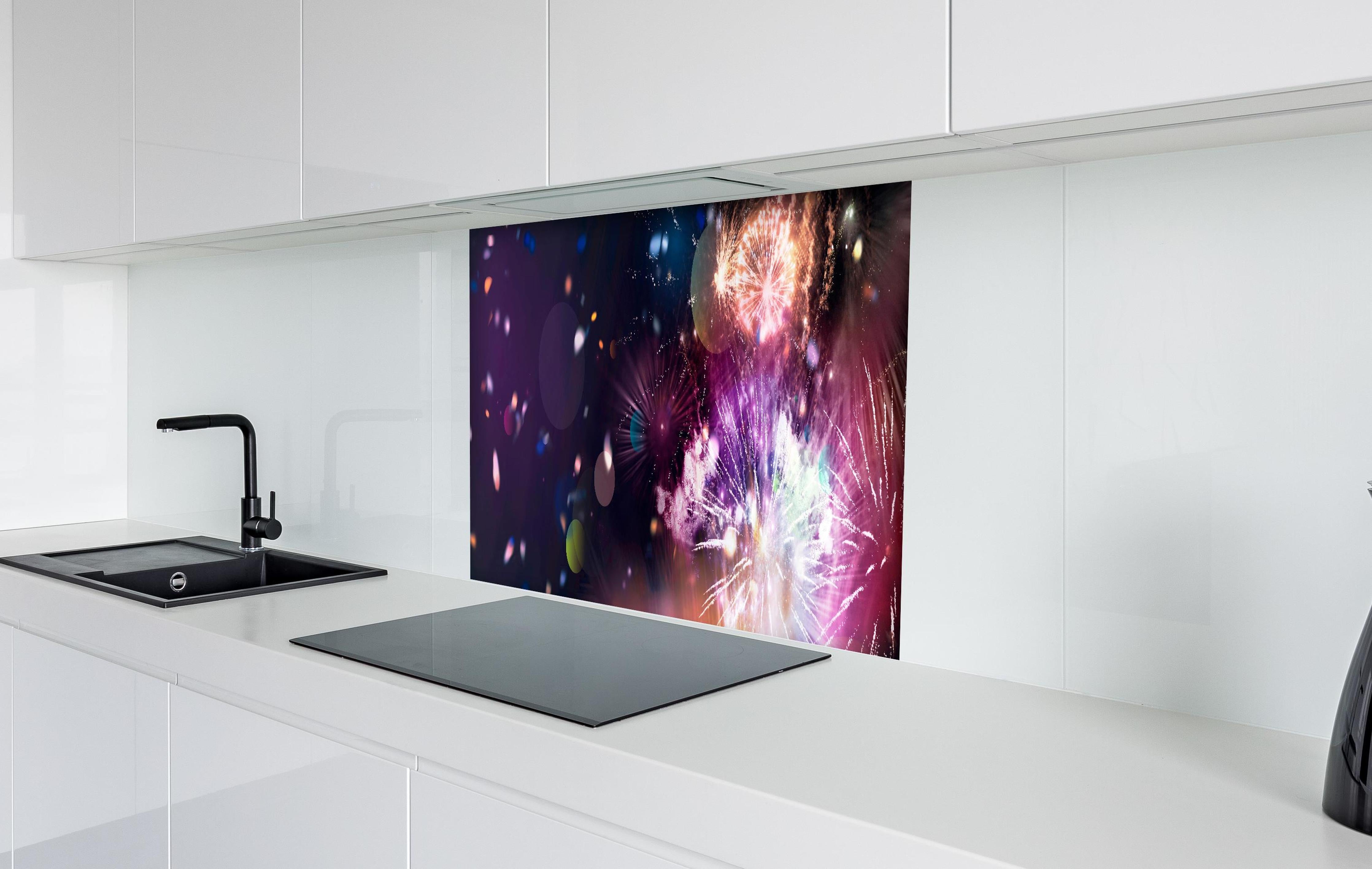 Spritzschutz - Prachtvolles Feuerwerk und schillerndes Konfetti hinter einem Cerankochfeld zwischen Holz-Kochutensilien
