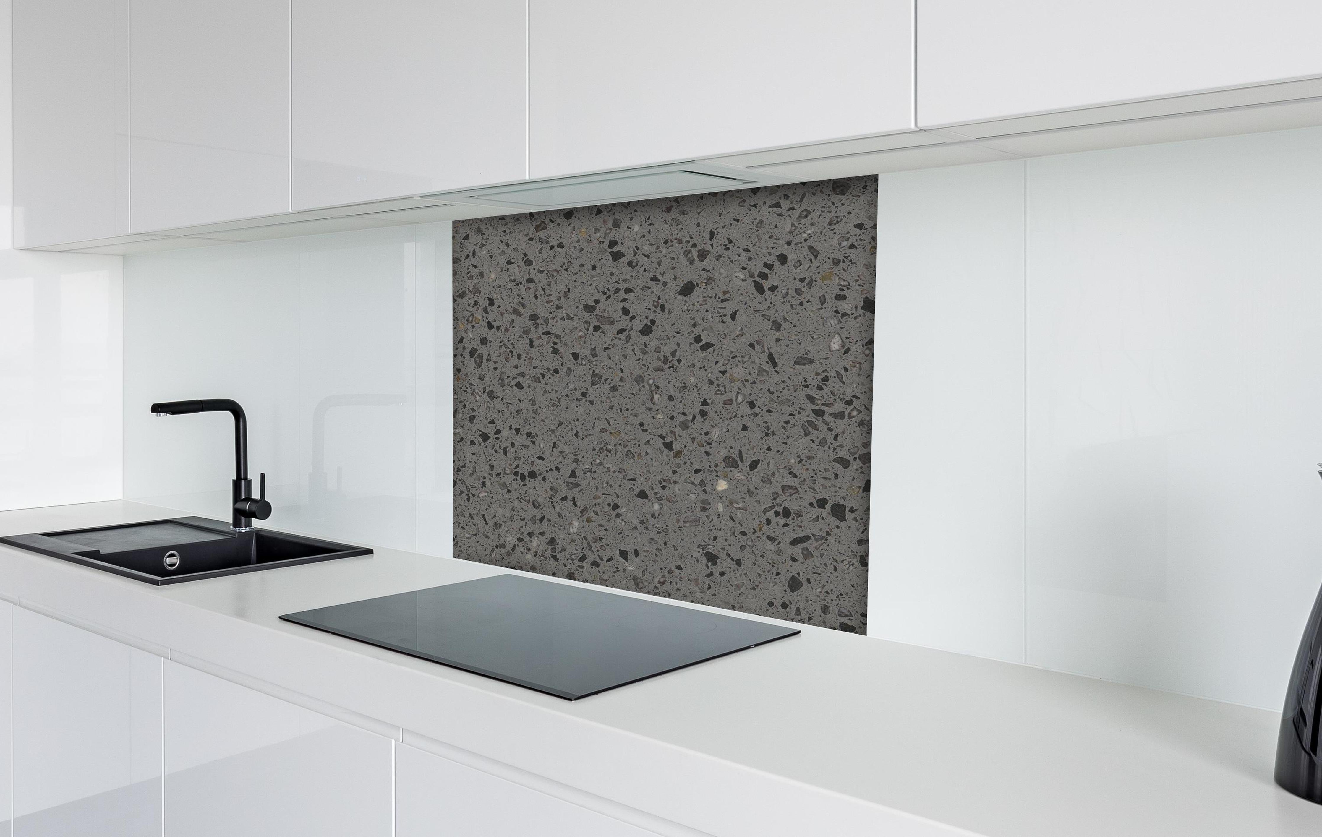 Spritzschutz - Quarz FusionStone Grey hinter einem Cerankochfeld zwischen Holz-Kochutensilien
