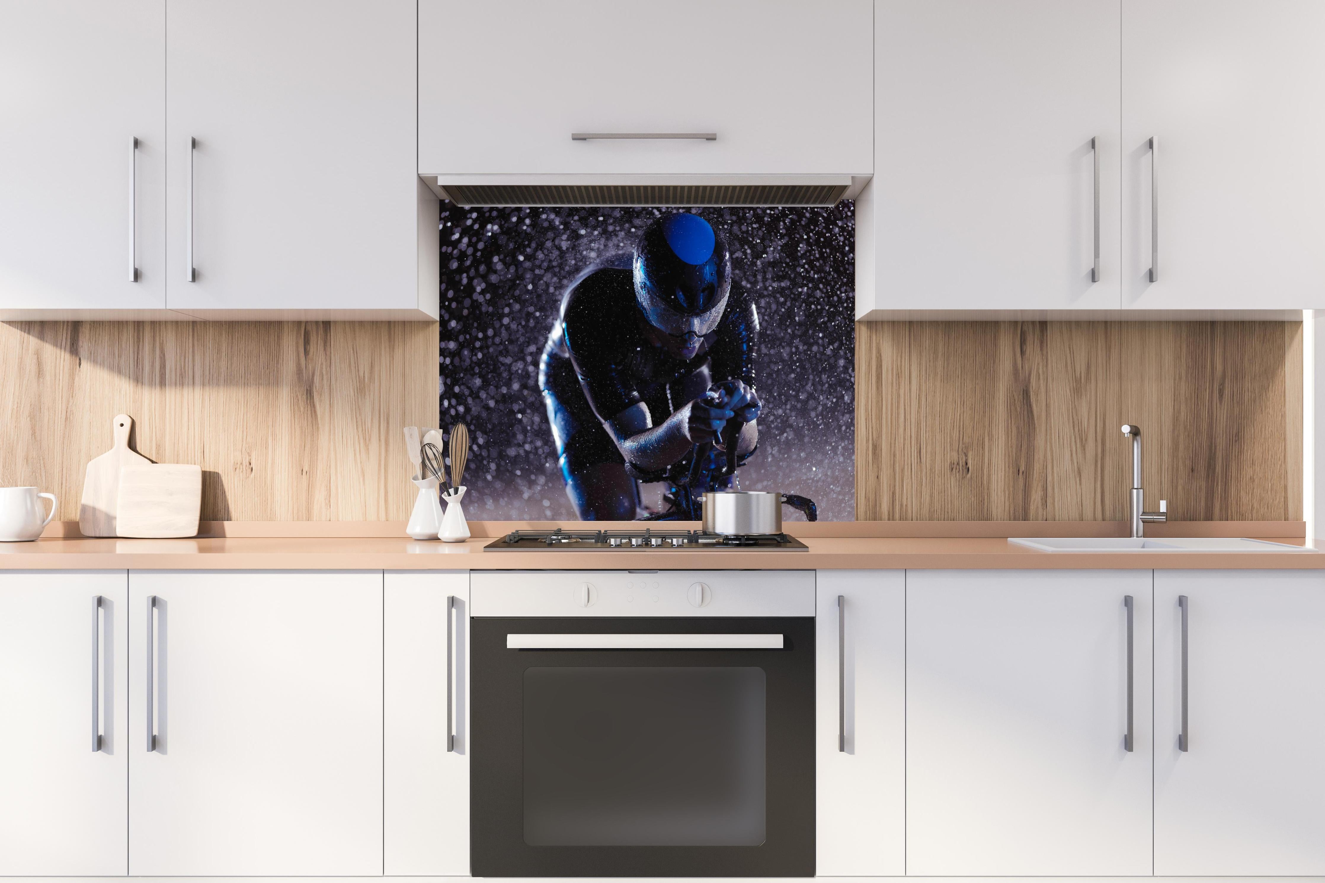 Spritzschutz - Radfahrer nachts bei Regen hinter einem Cerankochfeld zwischen Holz-Kochutensilien
