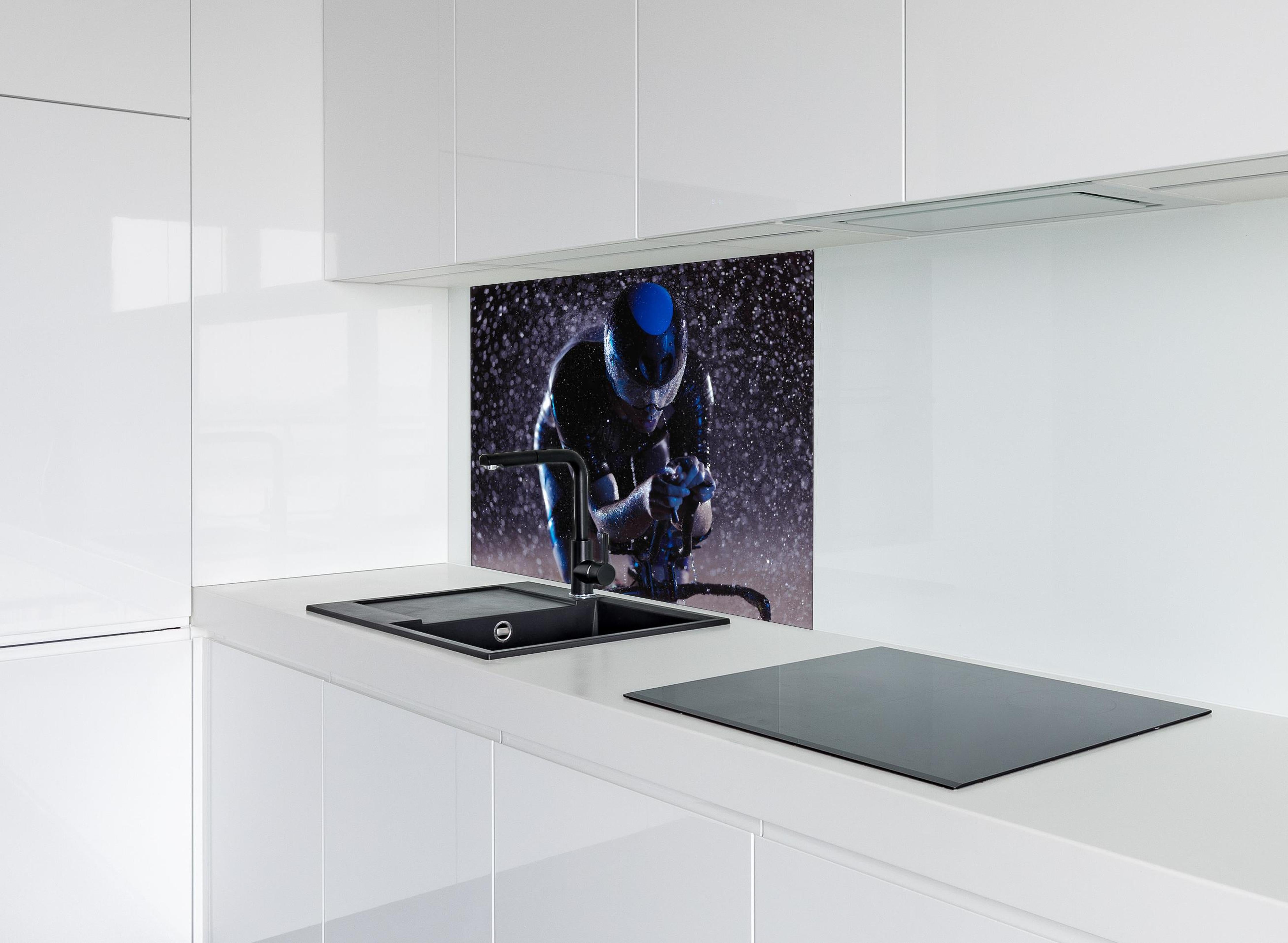 Spritzschutz - Radfahrer nachts bei Regen hinter einem Cerankochfeld zwischen Holz-Kochutensilien
