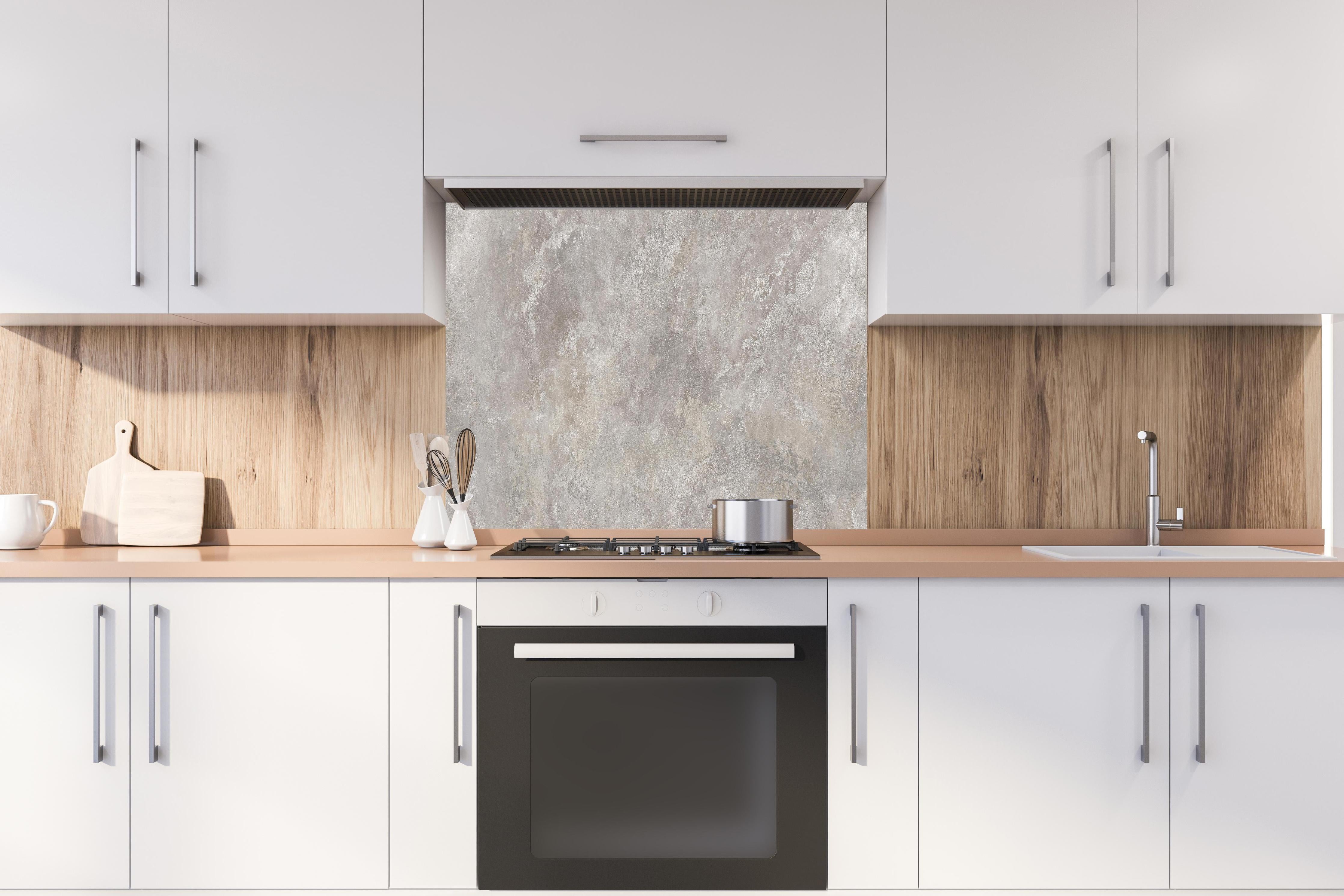 Spritzschutz - Raue Zement Struktur  hinter einem Cerankochfeld zwischen Holz-Kochutensilien
