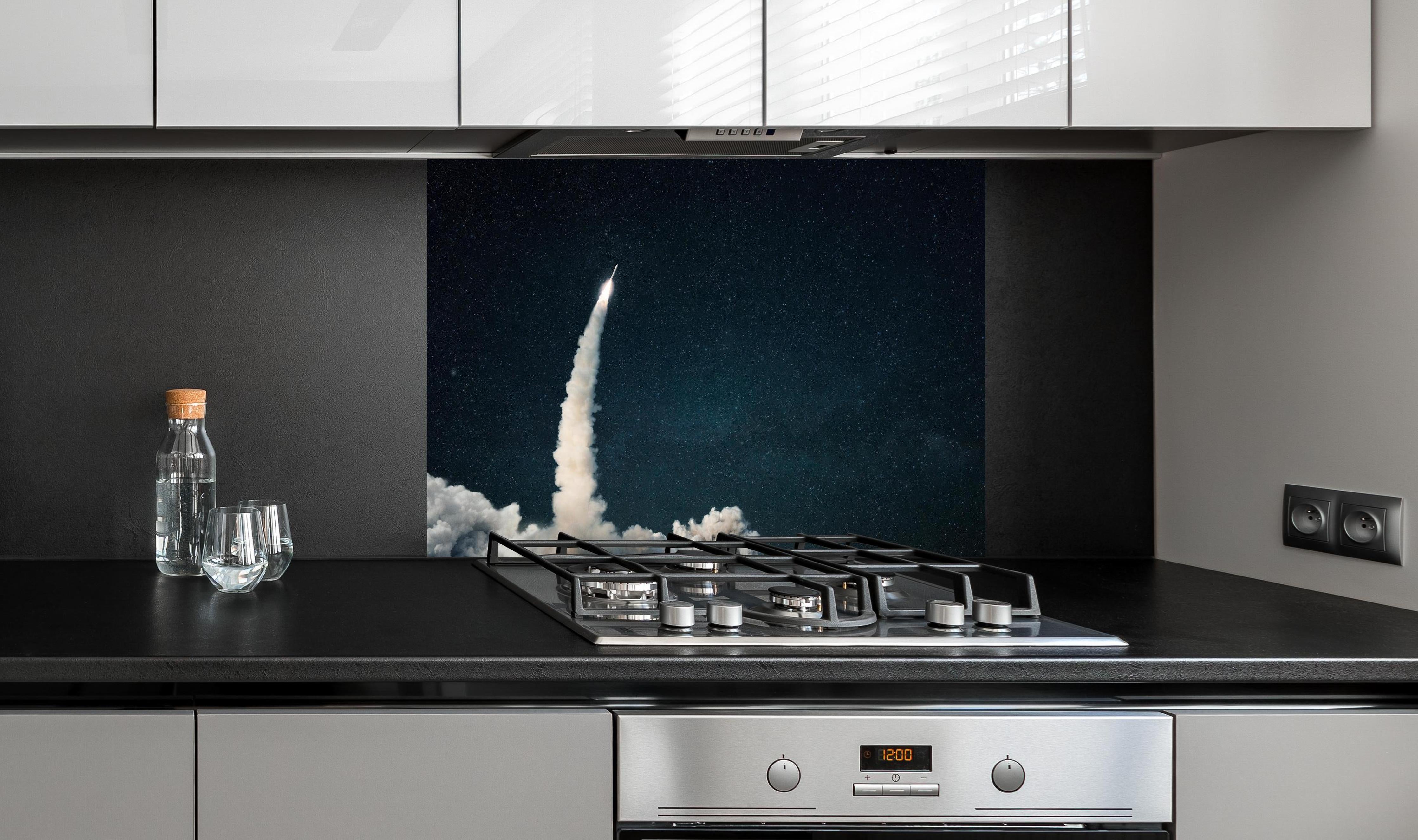 Spritzschutz - Raumschiffstart in den Weltraum hinter einem Cerankochfeld zwischen Holz-Kochutensilien
