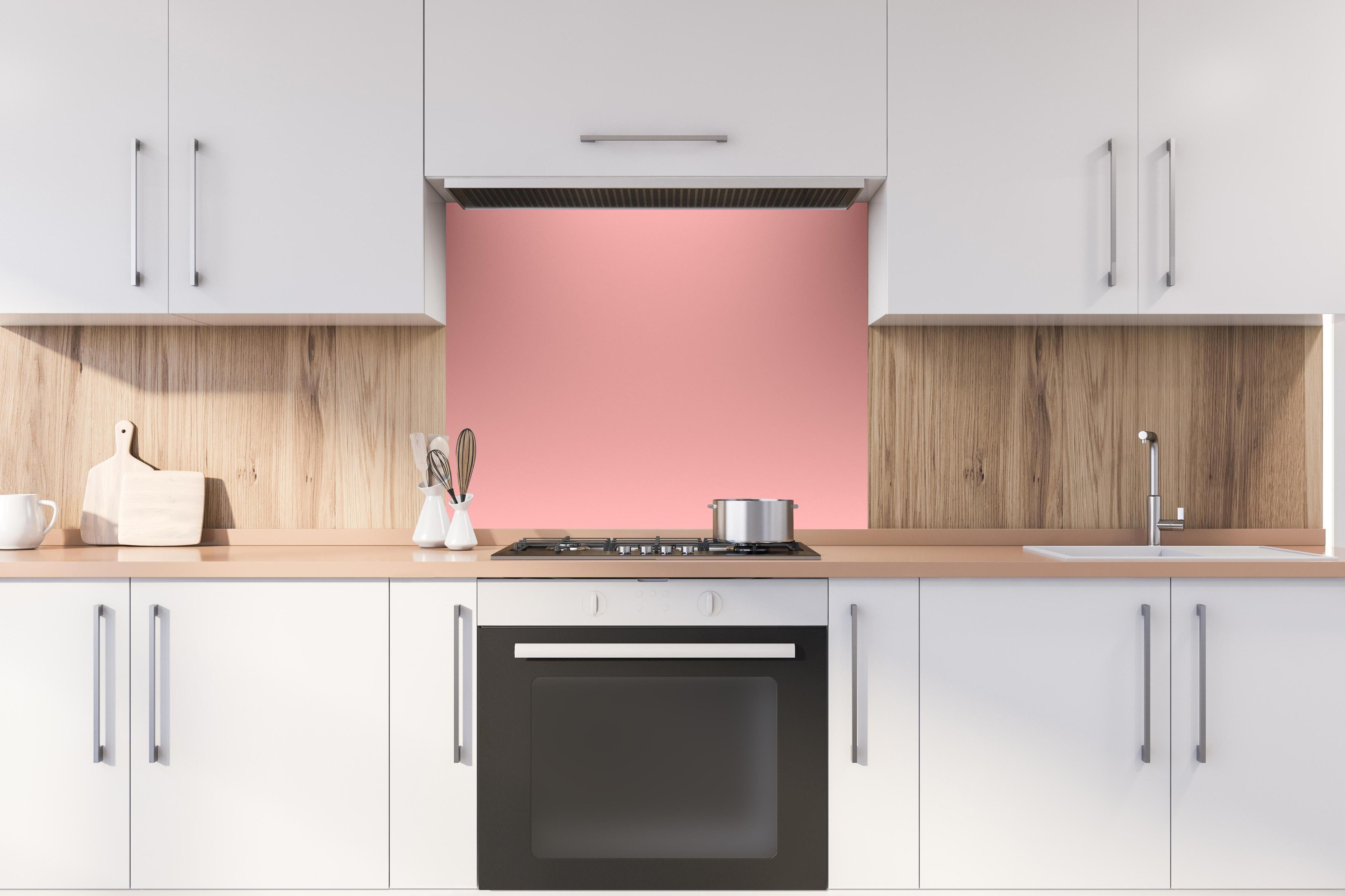 Spritzschutz - Rosa Oberfläche - Papiertextur hinter einem Cerankochfeld zwischen Holz-Kochutensilien
