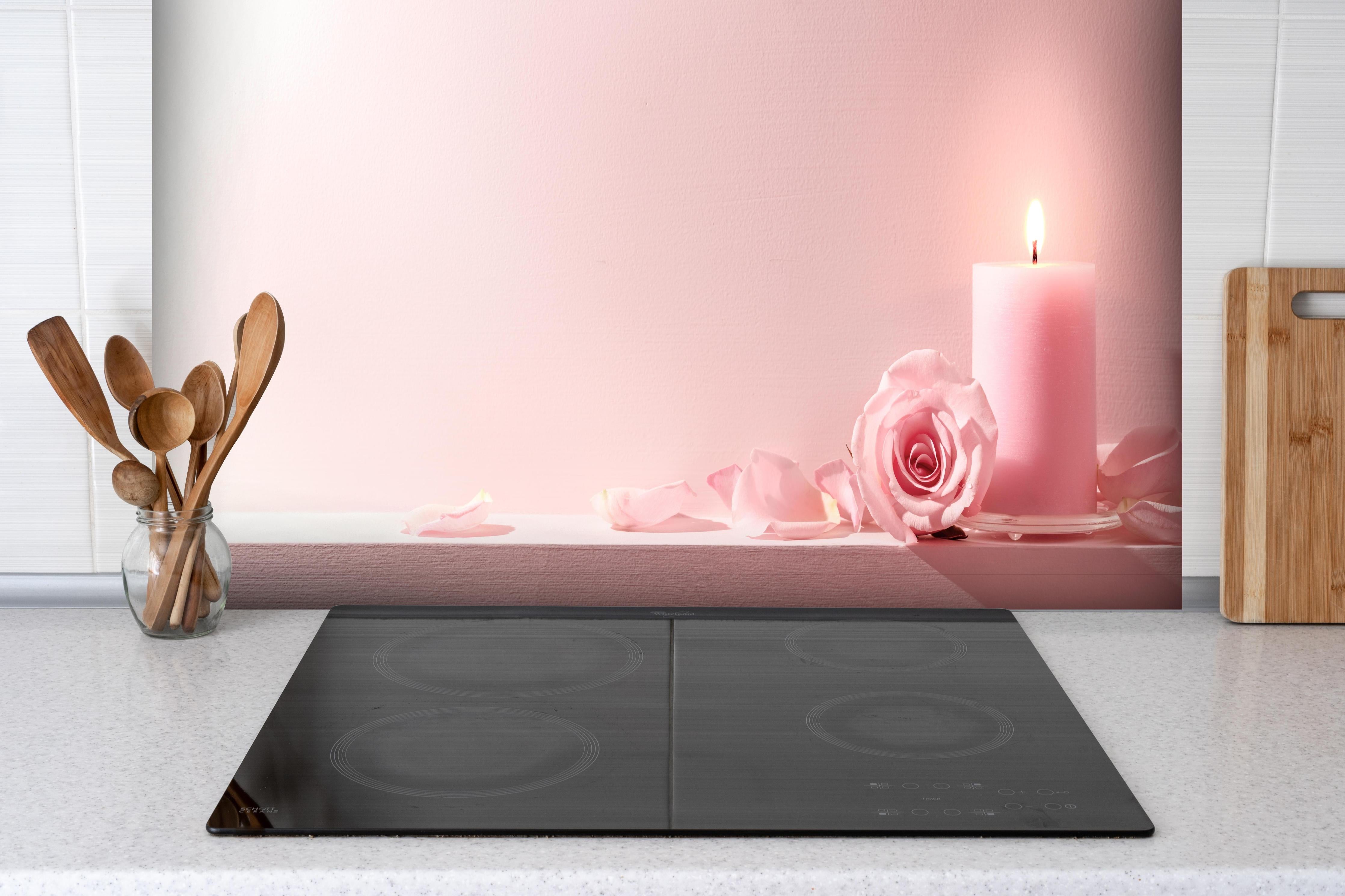 Spritzschutz - Rosa Rosen und Kerze auf einem rosa Hintergrund hinter einem Cerankochfeld zwischen Holz-Kochutensilien
