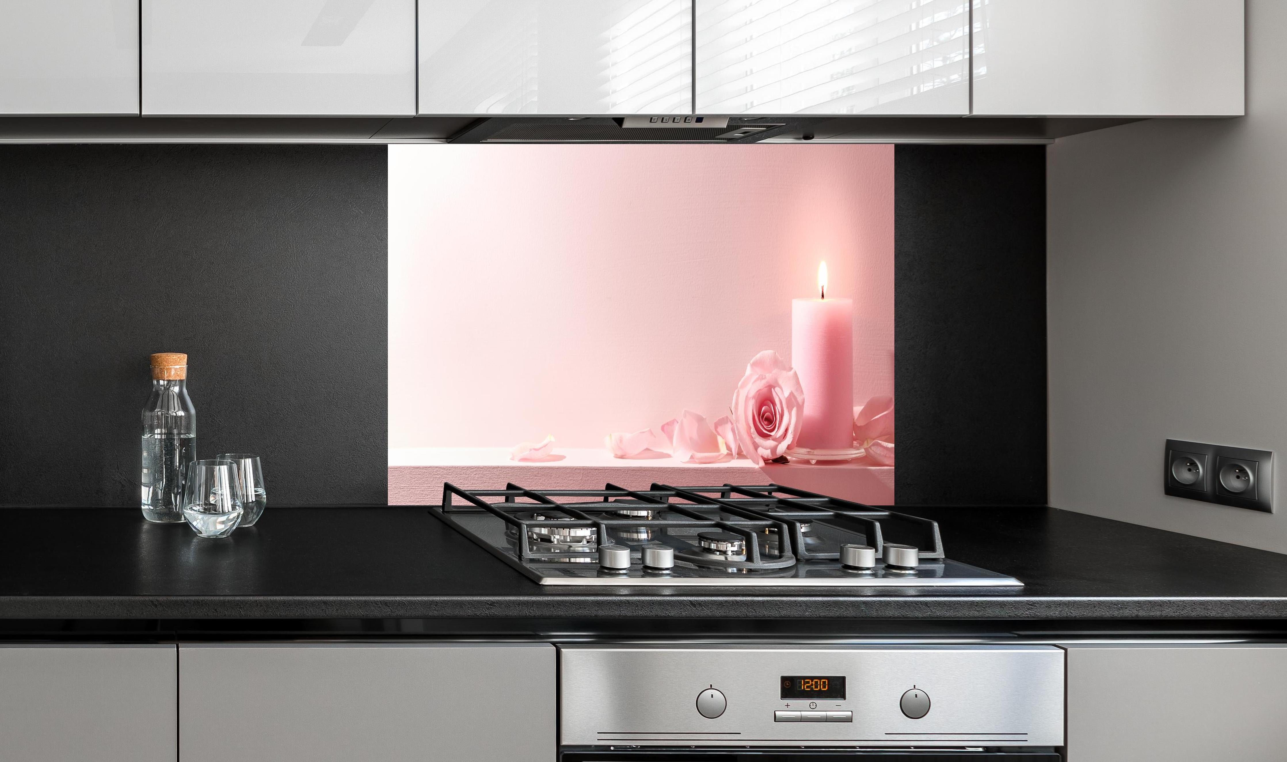 Spritzschutz - Rosa Rosen und Kerze auf einem rosa Hintergrund hinter einem Cerankochfeld zwischen Holz-Kochutensilien
