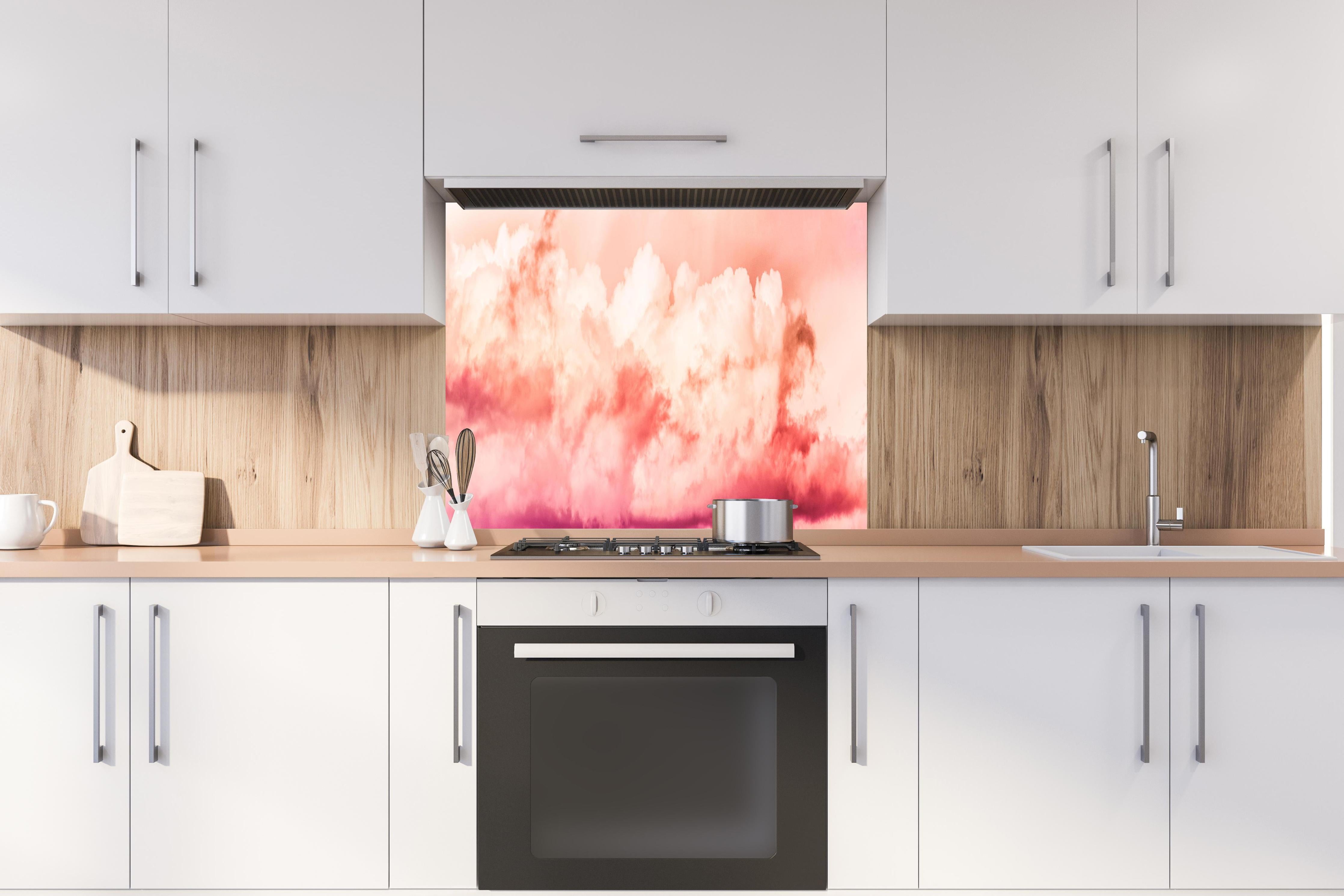 Spritzschutz - Rosa Wolkenhimmel hinter einem Cerankochfeld zwischen Holz-Kochutensilien

