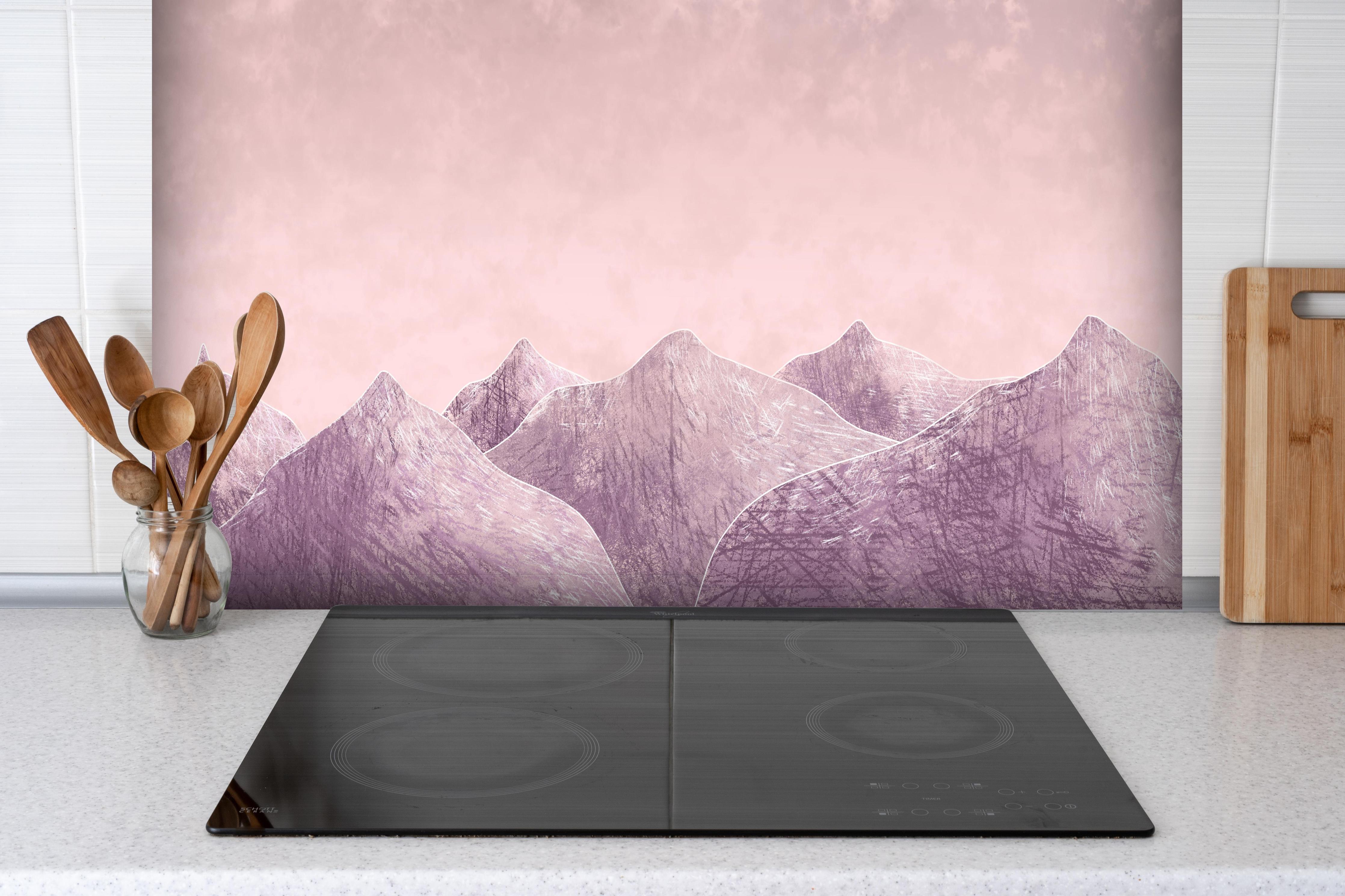 Spritzschutz - Rosa-lilane Berglandschaft - Kunstmalerei hinter einem Cerankochfeld zwischen Holz-Kochutensilien
