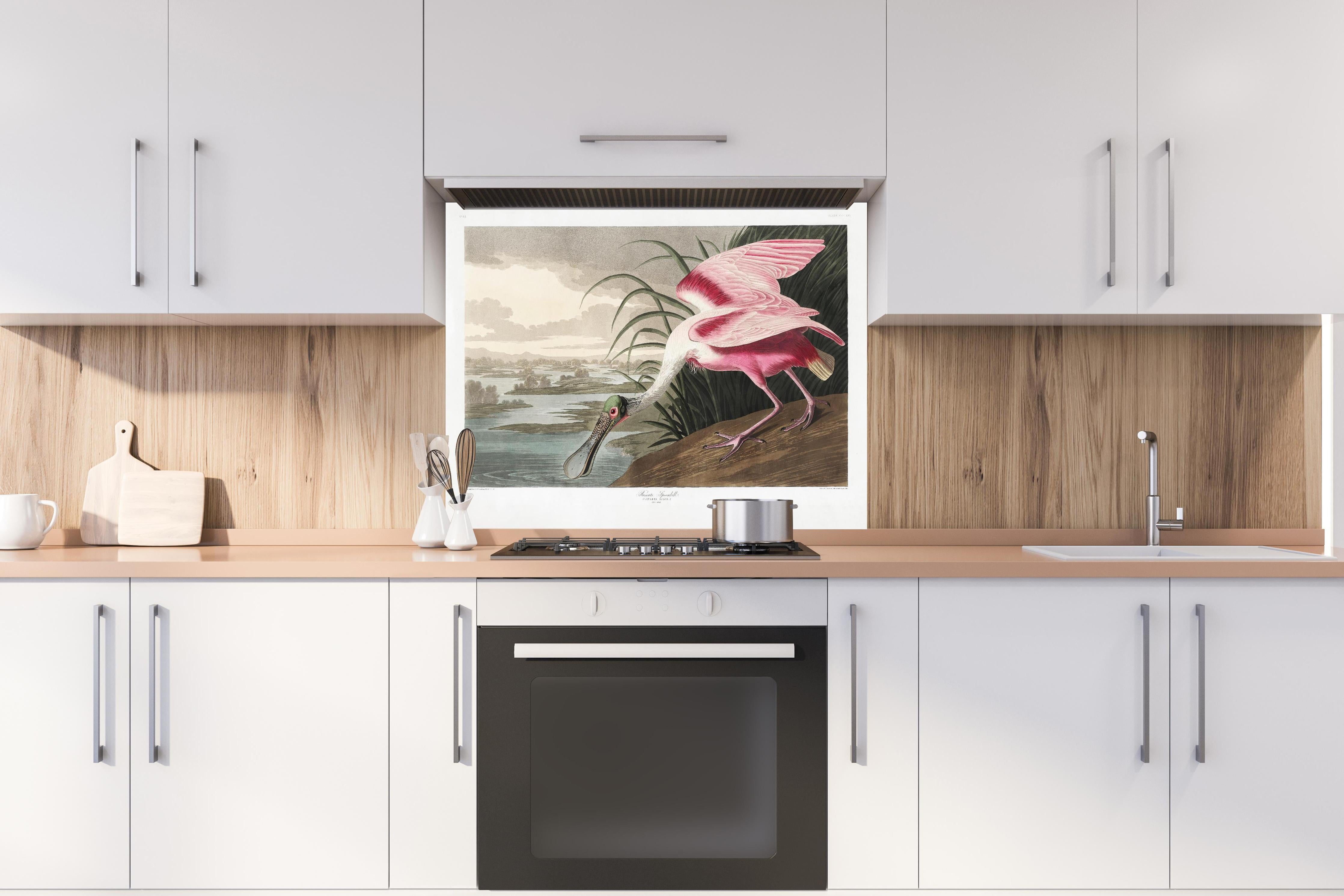 Spritzschutz - Rosalöffler hinter einem Cerankochfeld zwischen Holz-Kochutensilien
