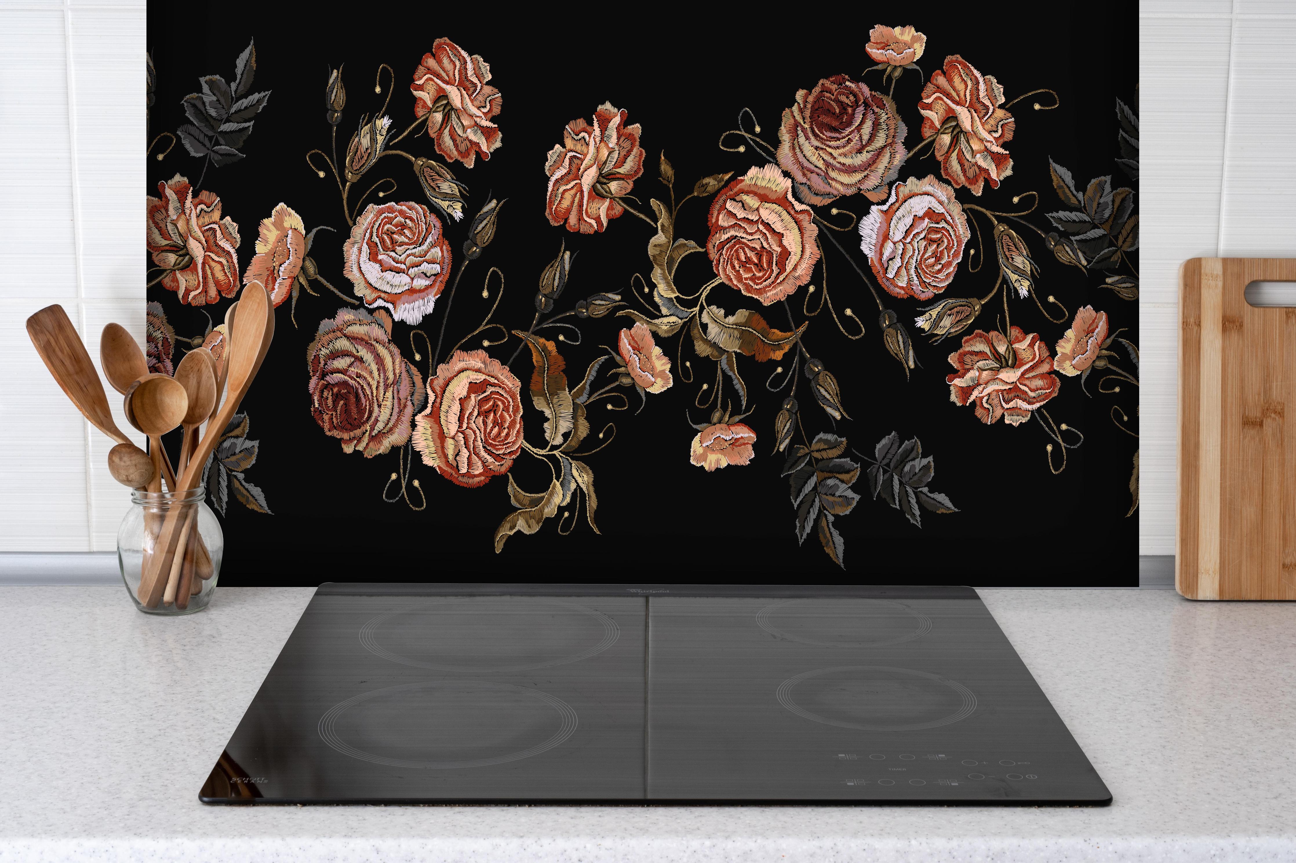 Spritzschutz - Rosen in der Dunkelheit hinter einem Cerankochfeld zwischen Holz-Kochutensilien
