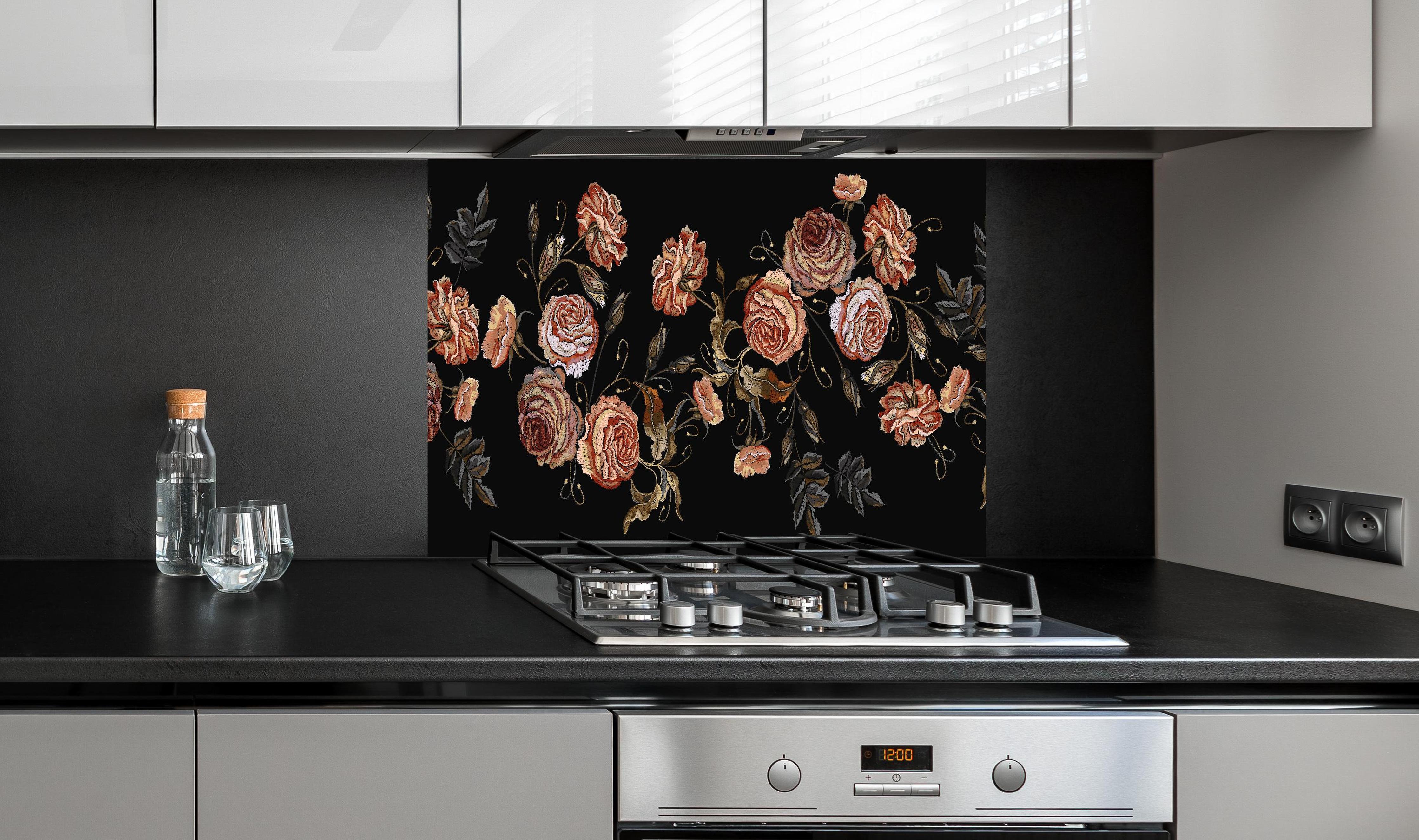 Spritzschutz - Rosen in der Dunkelheit hinter einem Cerankochfeld zwischen Holz-Kochutensilien
