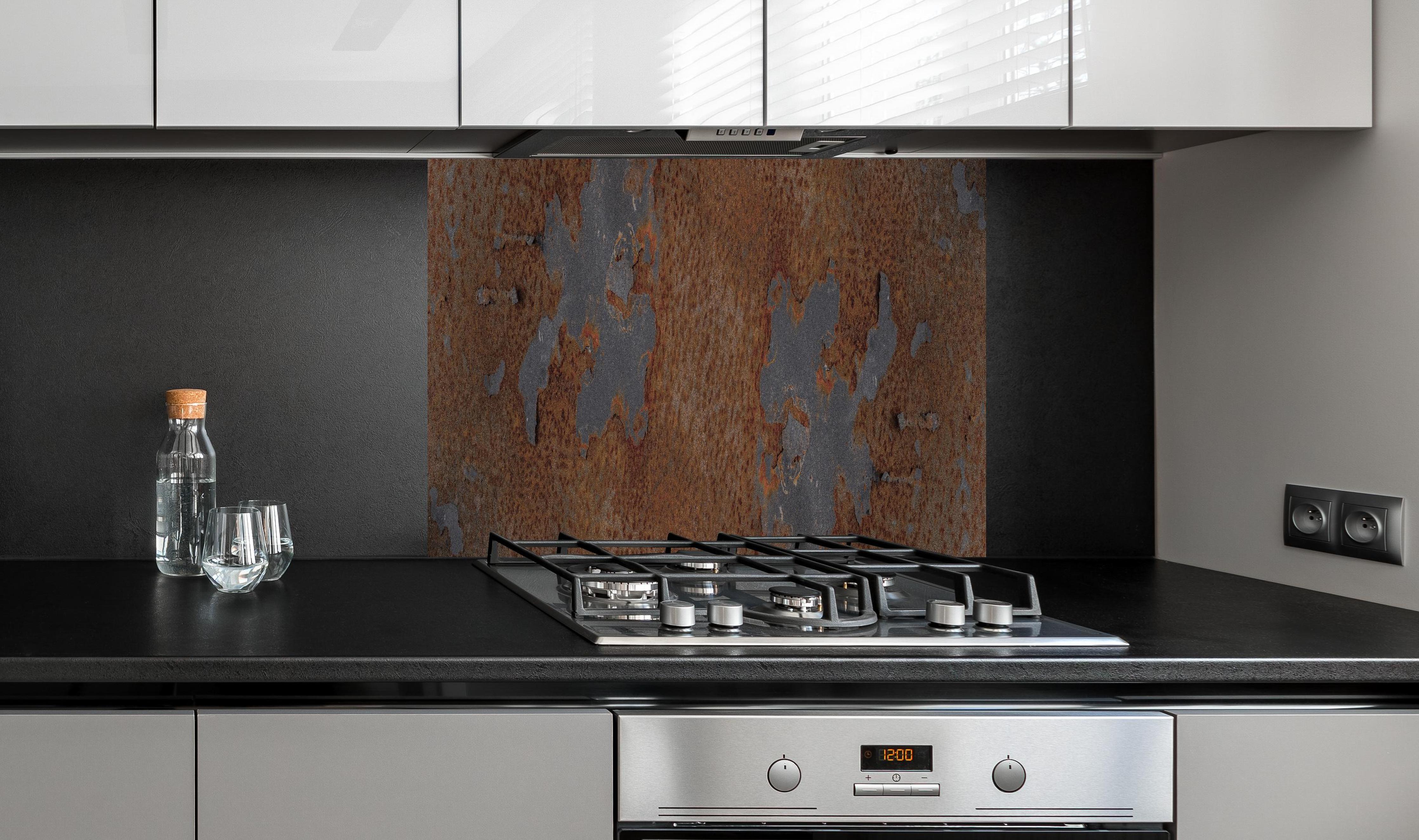 Spritzschutz - Rostiges Metall im Grunge-Stil hinter einem Cerankochfeld zwischen Holz-Kochutensilien
