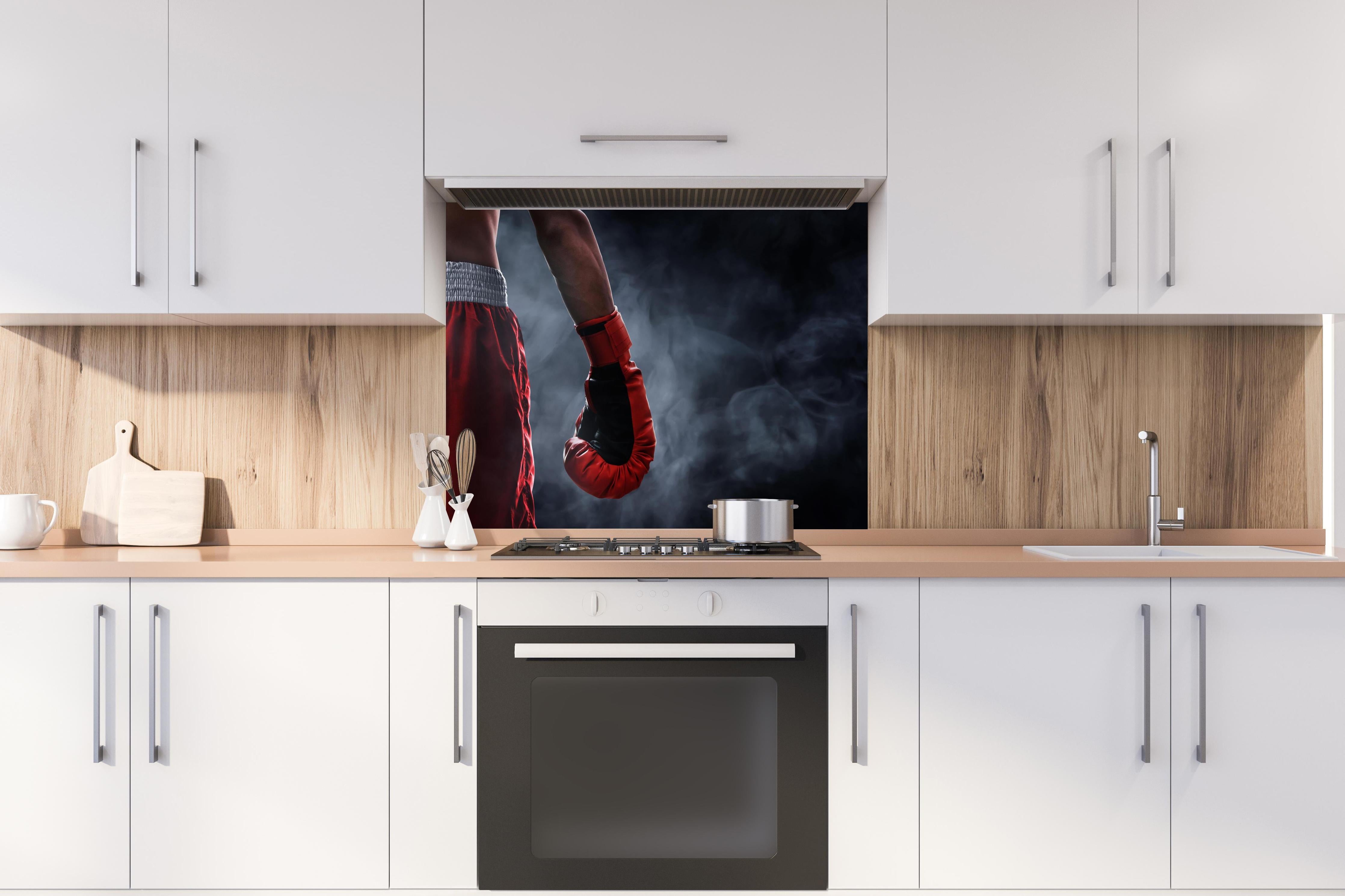 Spritzschutz - Roter Boxhandschuh hinter einem Cerankochfeld zwischen Holz-Kochutensilien
