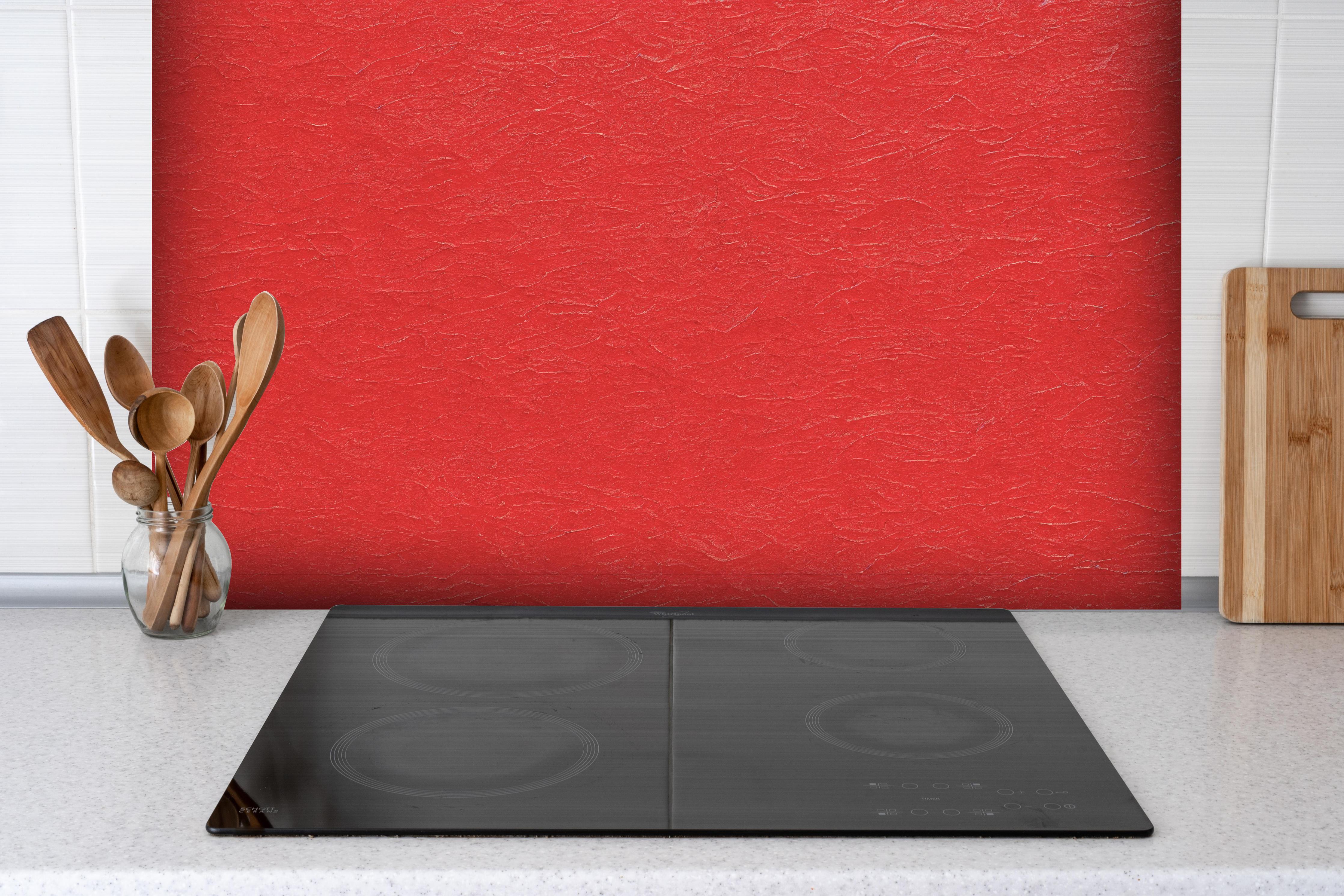 Spritzschutz - Rotes Wandmuster hinter einem Cerankochfeld zwischen Holz-Kochutensilien
