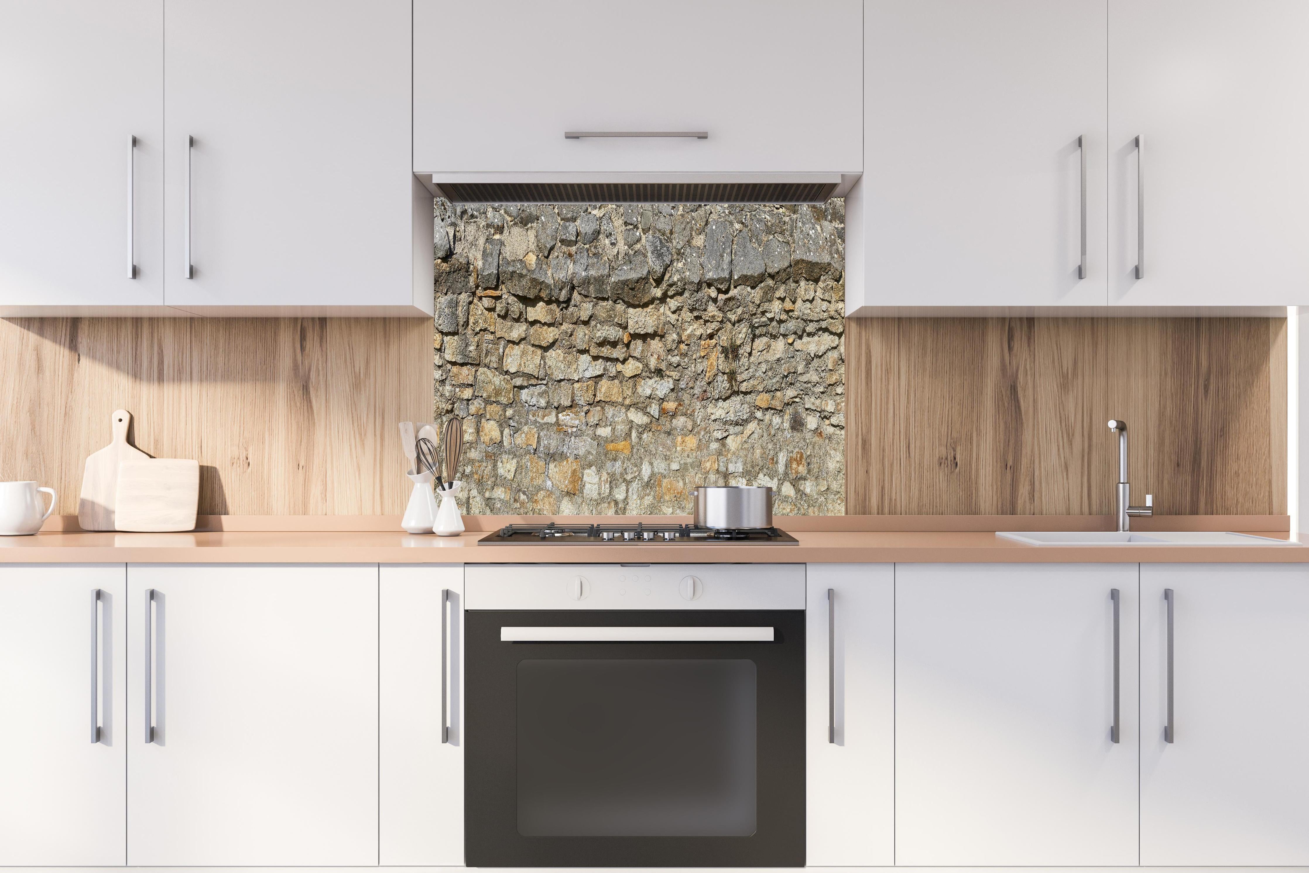 Spritzschutz - Rustikale Burgmauer hinter einem Cerankochfeld zwischen Holz-Kochutensilien
