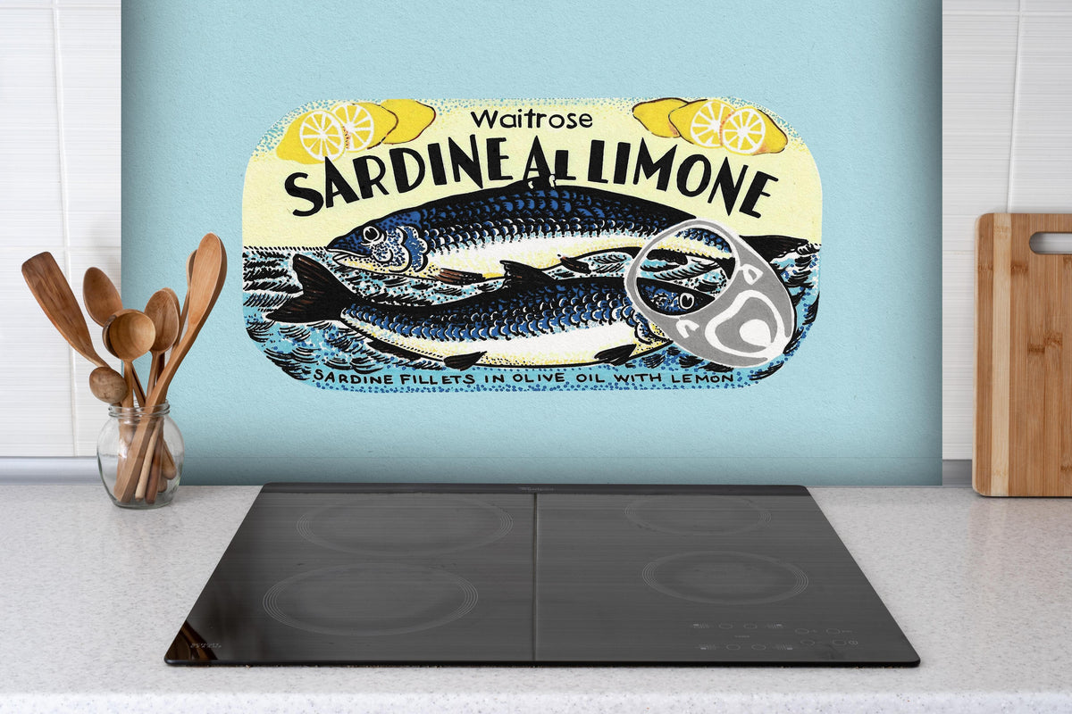 Spritzschutz - Sardine Al Limone hinter einem Cerankochfeld zwischen Holz-Kochutensilien
