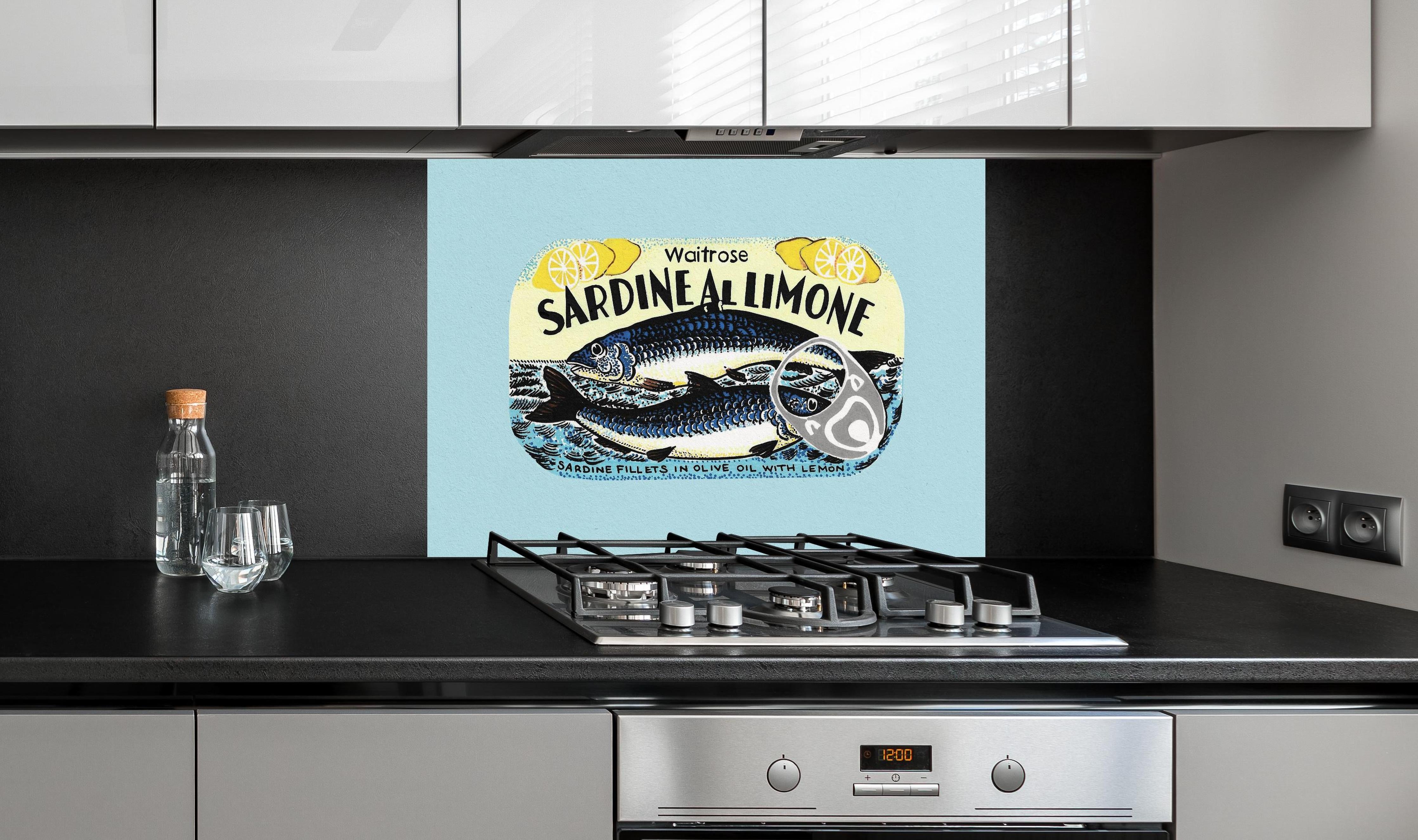 Spritzschutz - Sardine Al Limone hinter einem Cerankochfeld zwischen Holz-Kochutensilien
