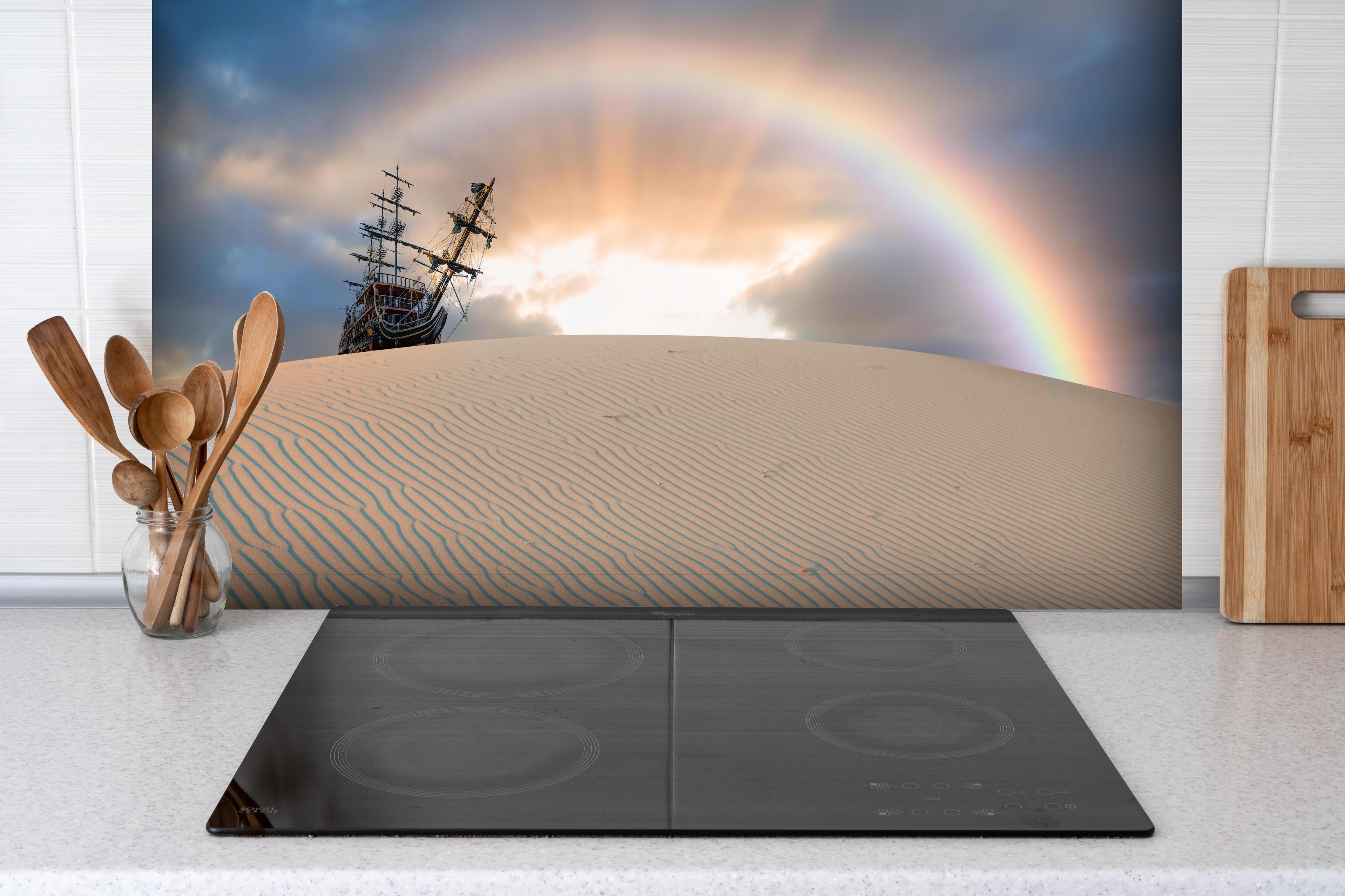 Spritzschutz - Schiff in Wüste mit Regenbogen bei Sonnenuntergang hinter einem Cerankochfeld zwischen Holz-Kochutensilien
