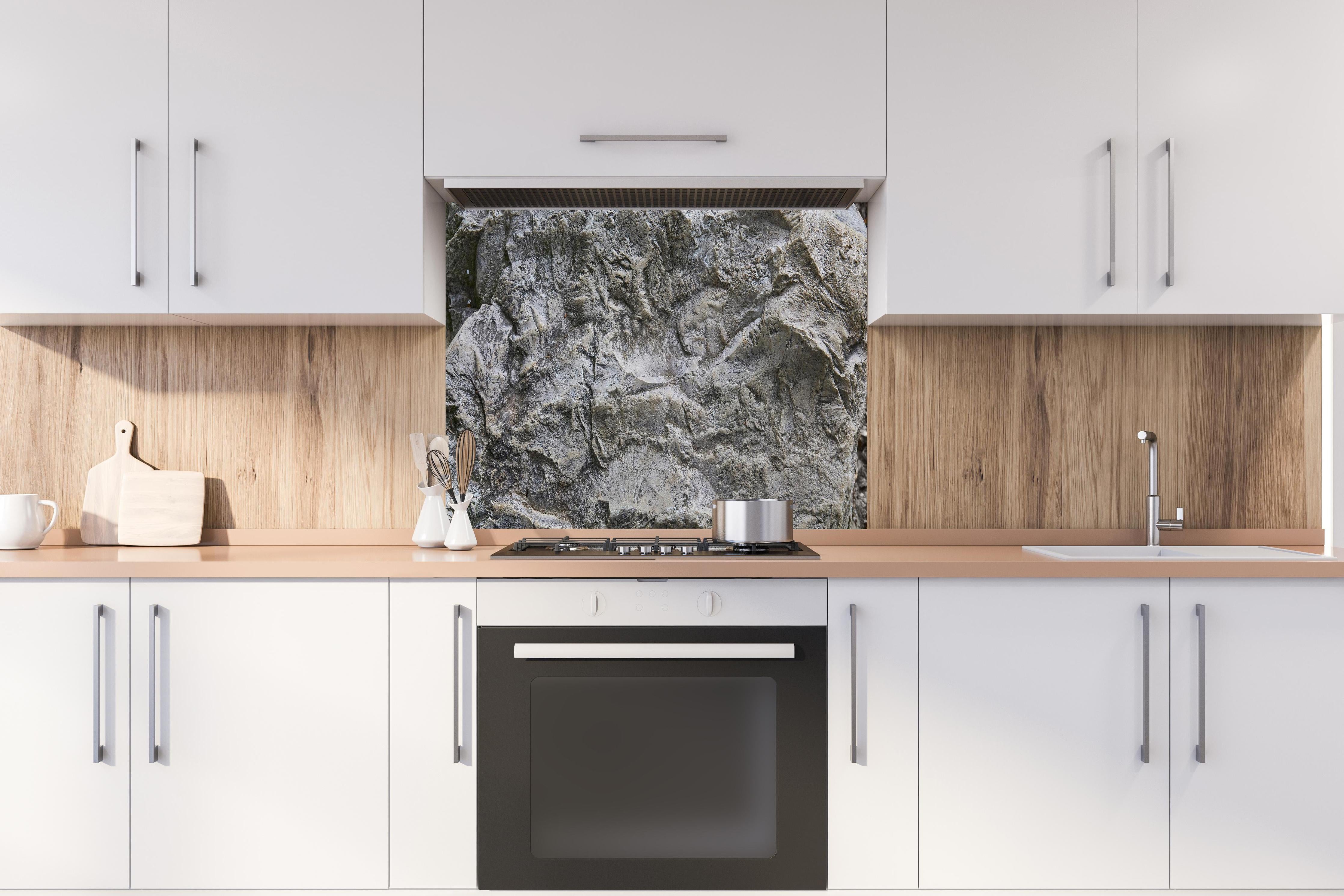 Spritzschutz - Schöne Felsstruktur - Granit hinter einem Cerankochfeld zwischen Holz-Kochutensilien
