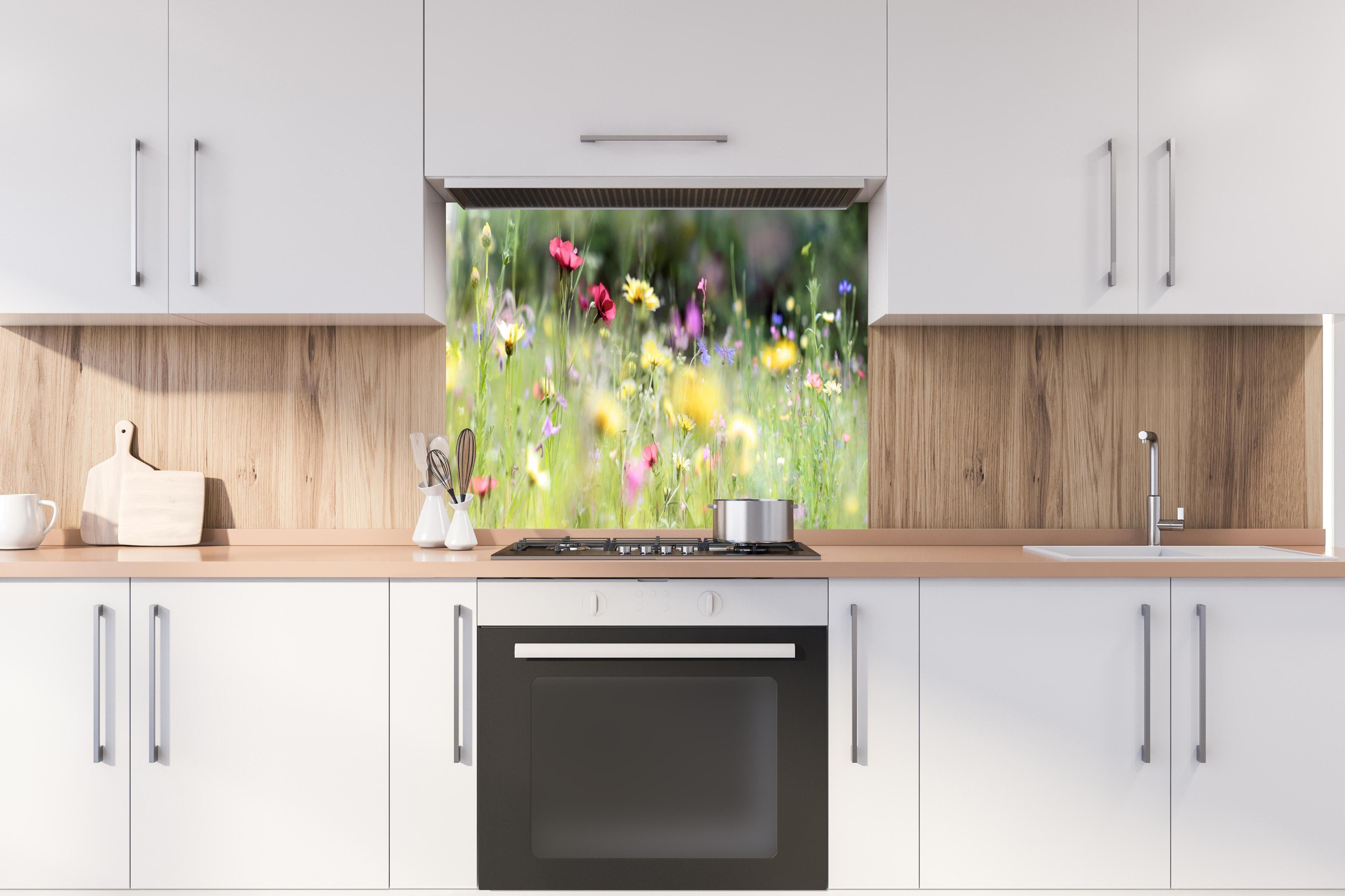 Spritzschutz - Schöne Wildblumenwiese hinter einem Cerankochfeld zwischen Holz-Kochutensilien
