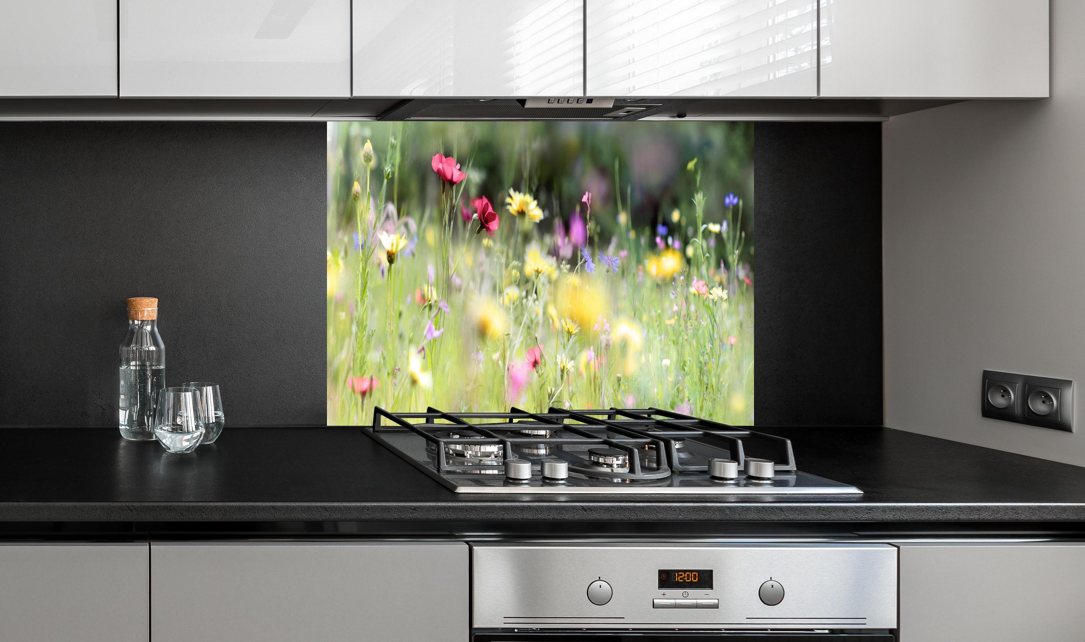 Spritzschutz - Schöne Wildblumenwiese hinter einem Cerankochfeld zwischen Holz-Kochutensilien
