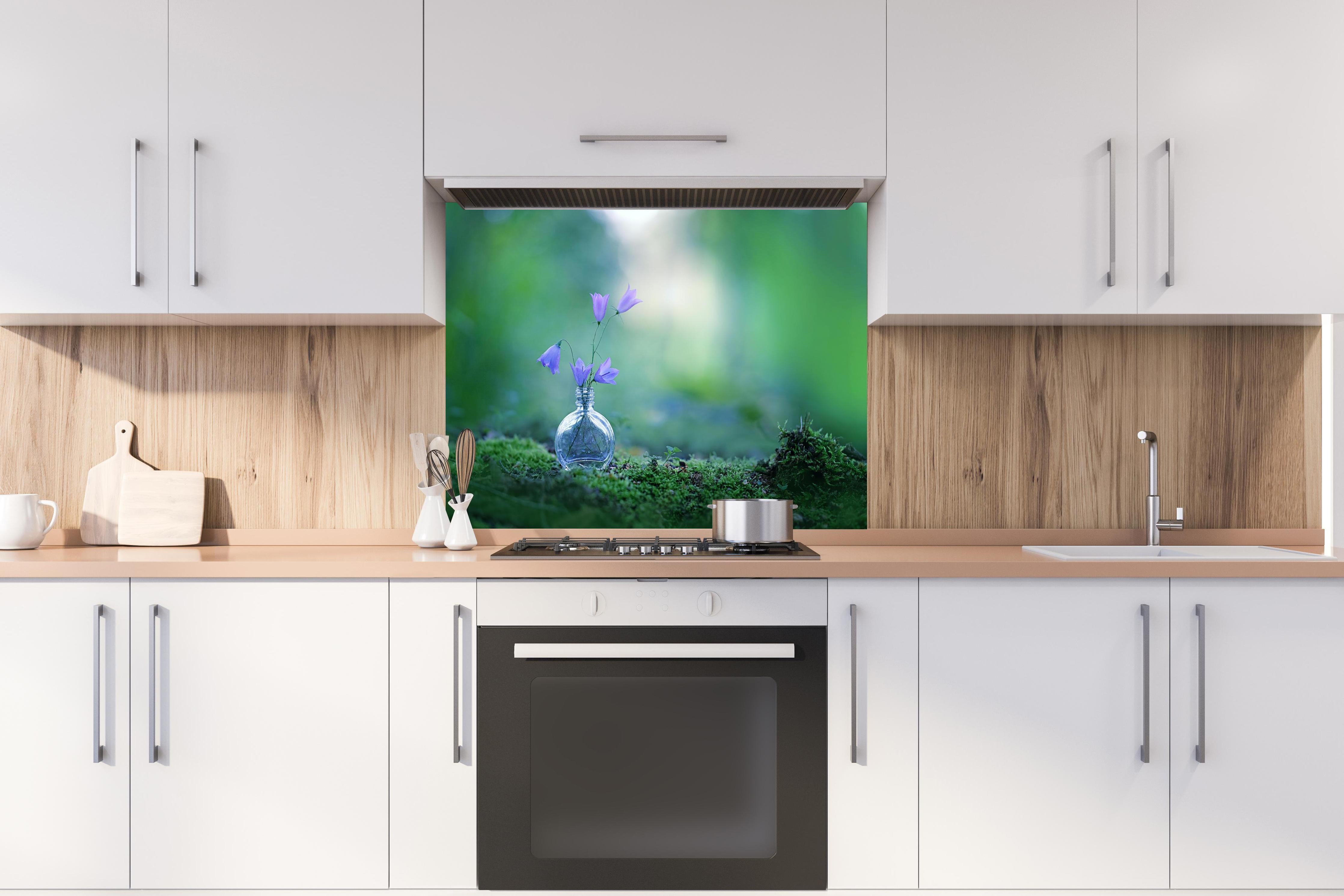 Spritzschutz - Schöne campanula Blumen hinter einem Cerankochfeld zwischen Holz-Kochutensilien
