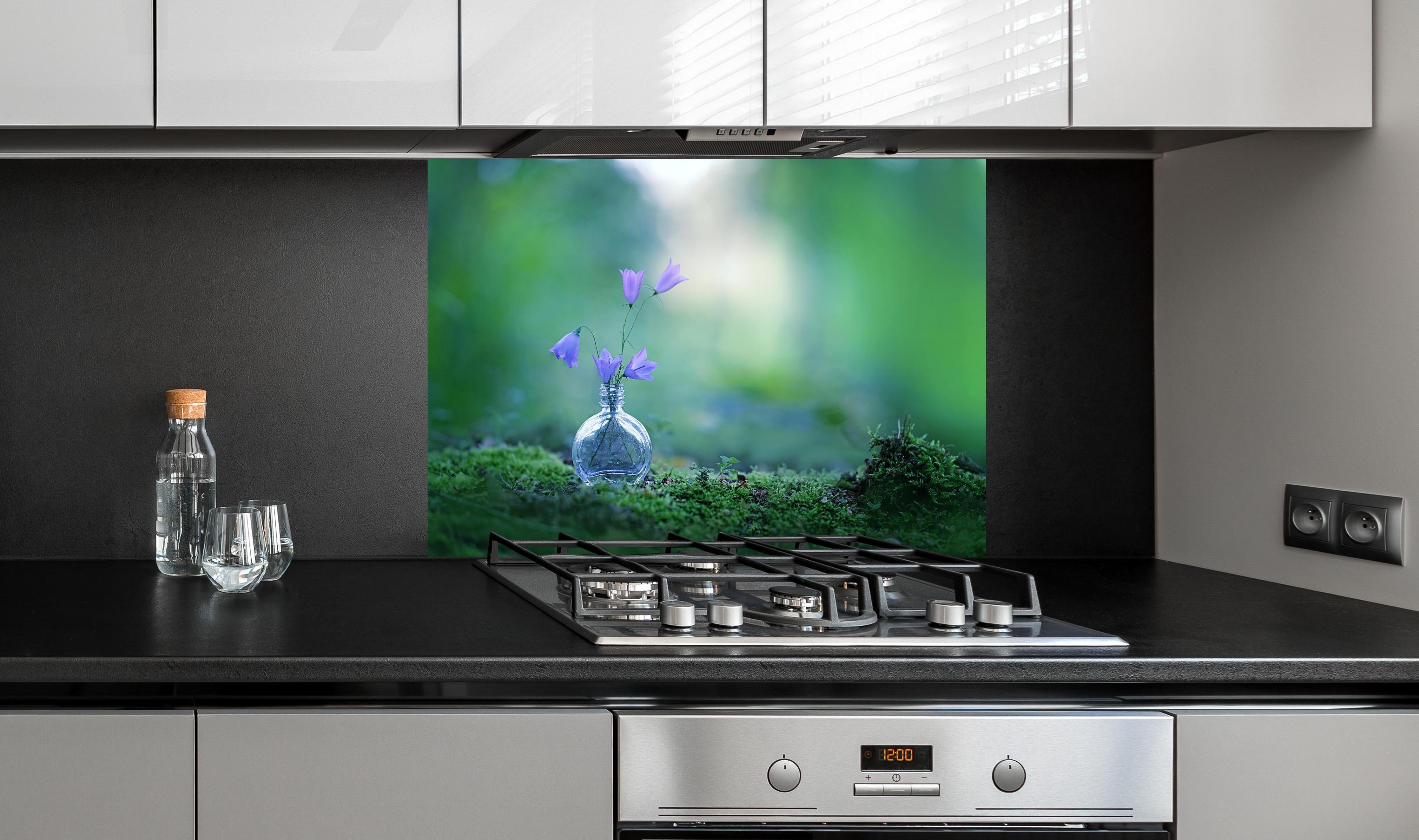 Spritzschutz - Schöne campanula Blumen hinter einem Cerankochfeld zwischen Holz-Kochutensilien
