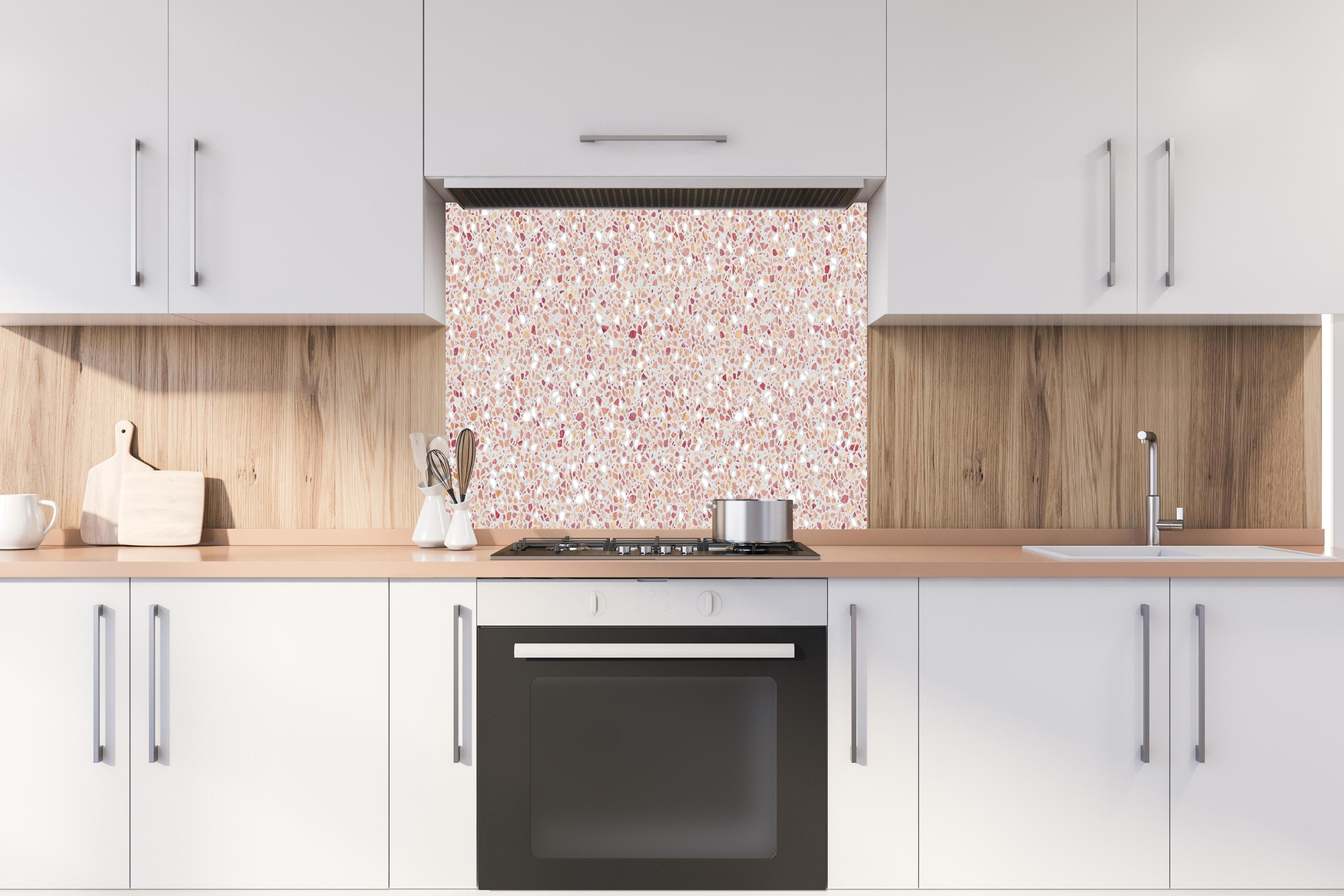 Spritzschutz - Schöne rote Terrazzo Stein Textur hinter einem Cerankochfeld zwischen Holz-Kochutensilien
