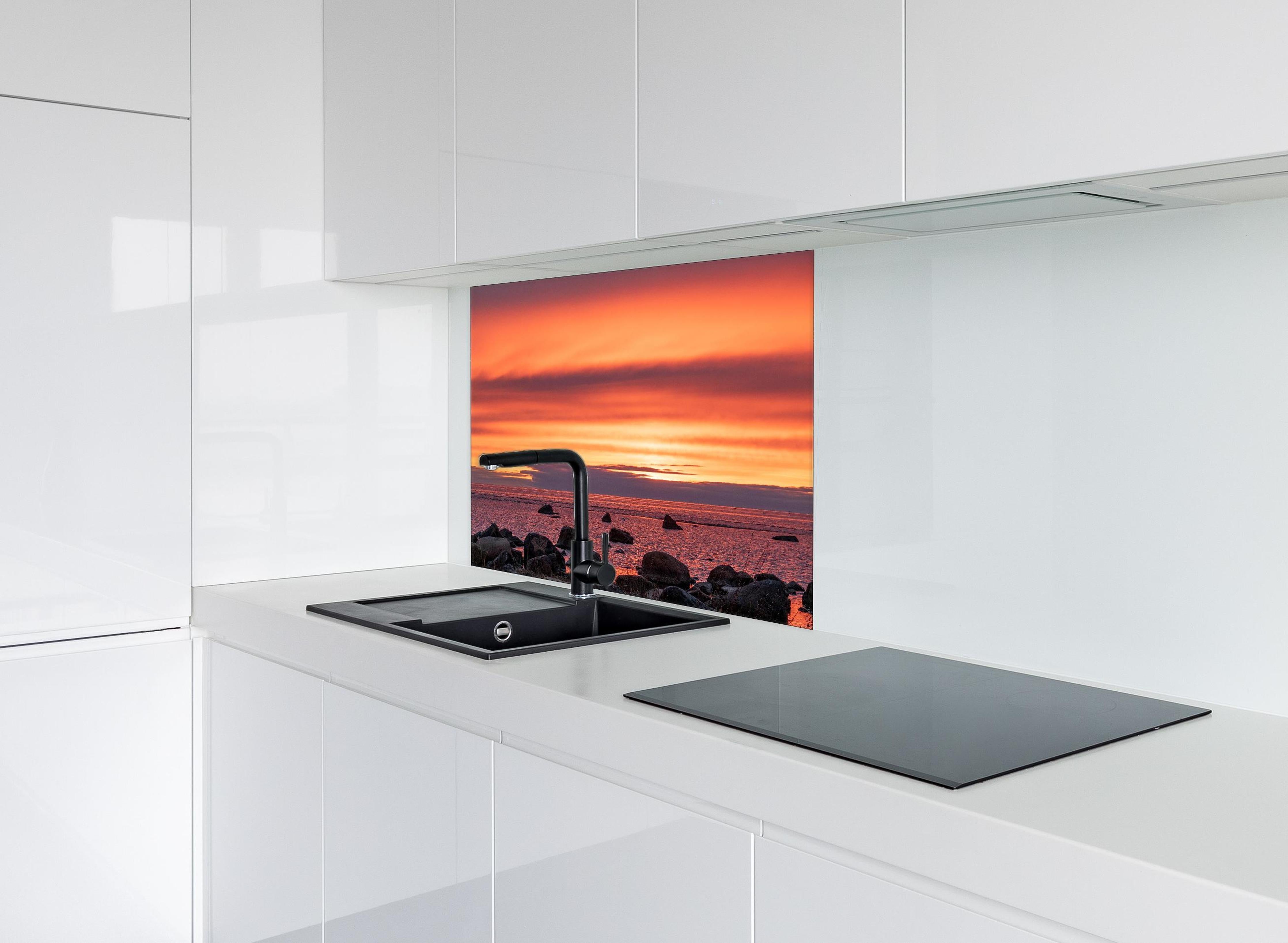 Spritzschutz - Schöner Sonnenuntergang am Meer hinter einem Cerankochfeld zwischen Holz-Kochutensilien
