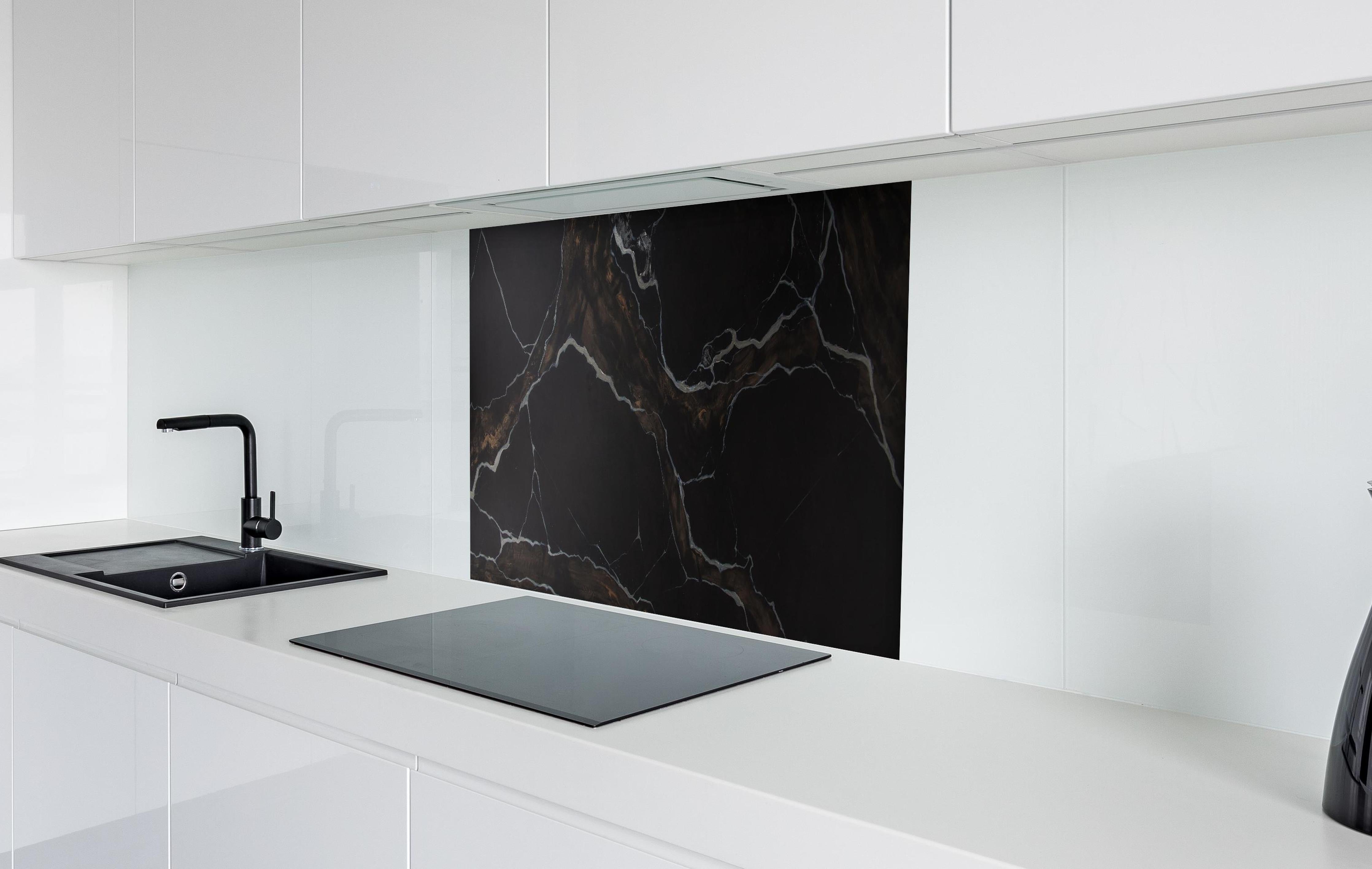 Spritzschutz - Schwarz-brauner Marmor hinter einem Cerankochfeld zwischen Holz-Kochutensilien
