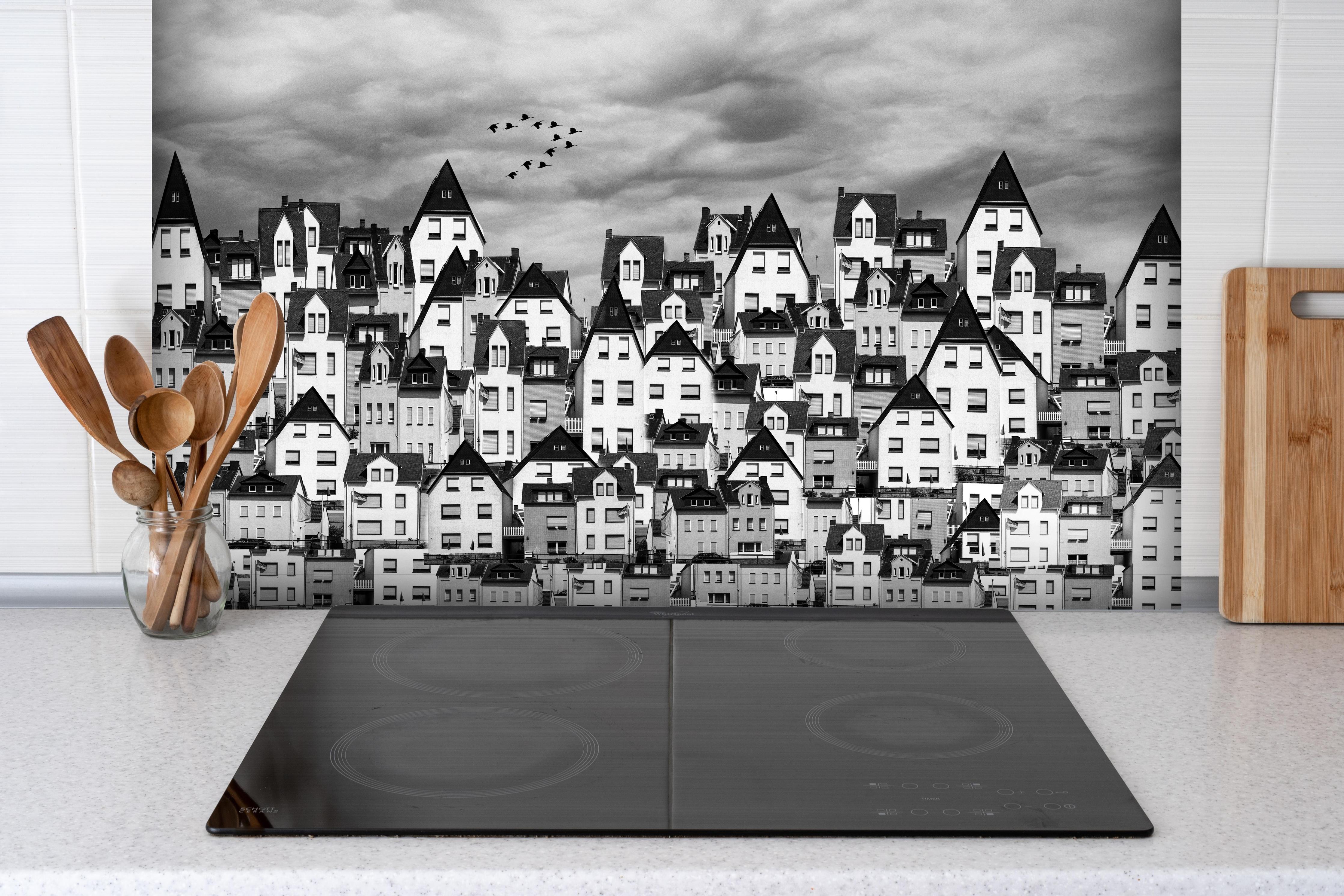 Spritzschutz - Schwarz-weiße Dachlandschaft mit Vögeln hinter einem Cerankochfeld zwischen Holz-Kochutensilien
