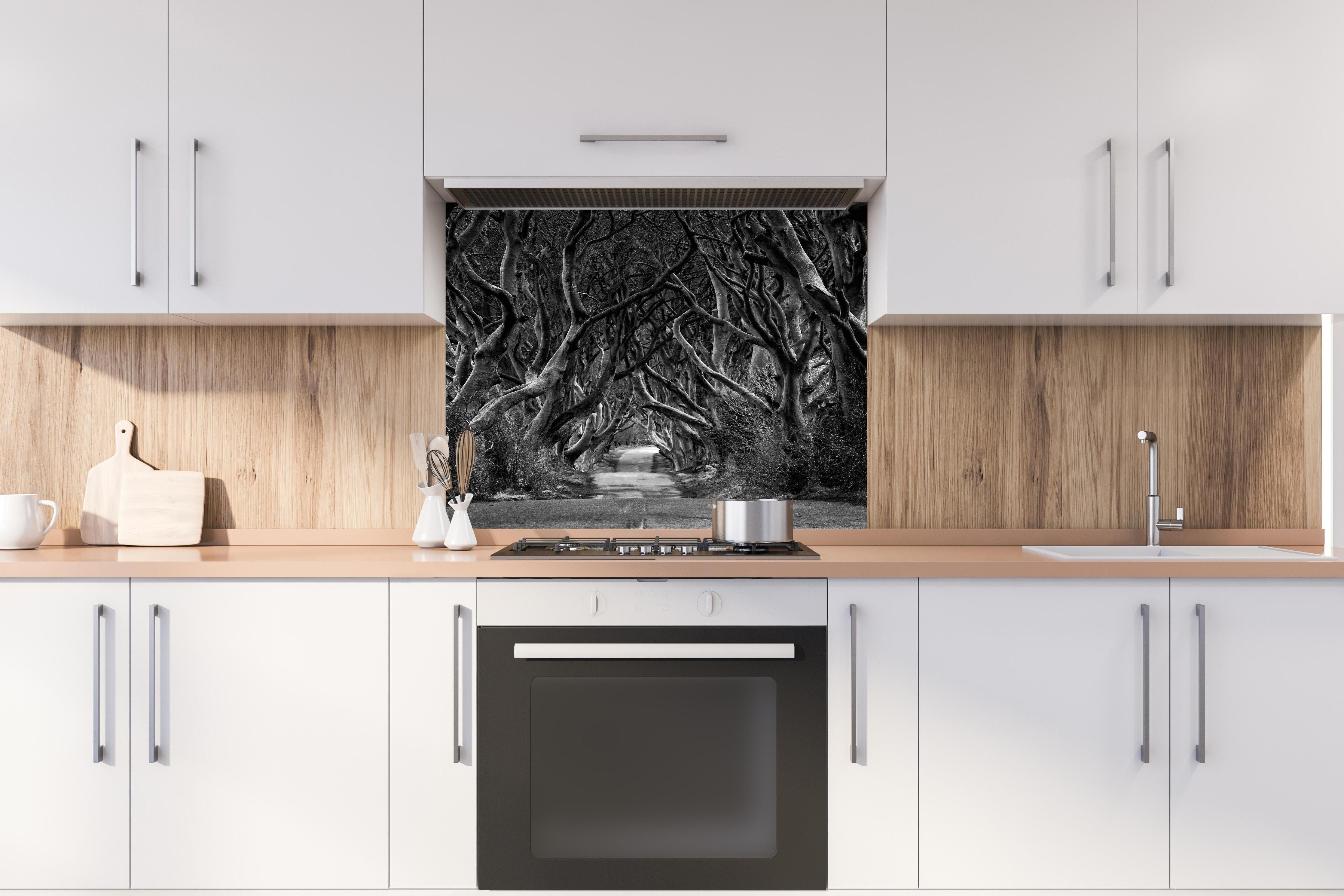 Spritzschutz - Schwarz, weißer Waldweg hinter einem Cerankochfeld zwischen Holz-Kochutensilien
