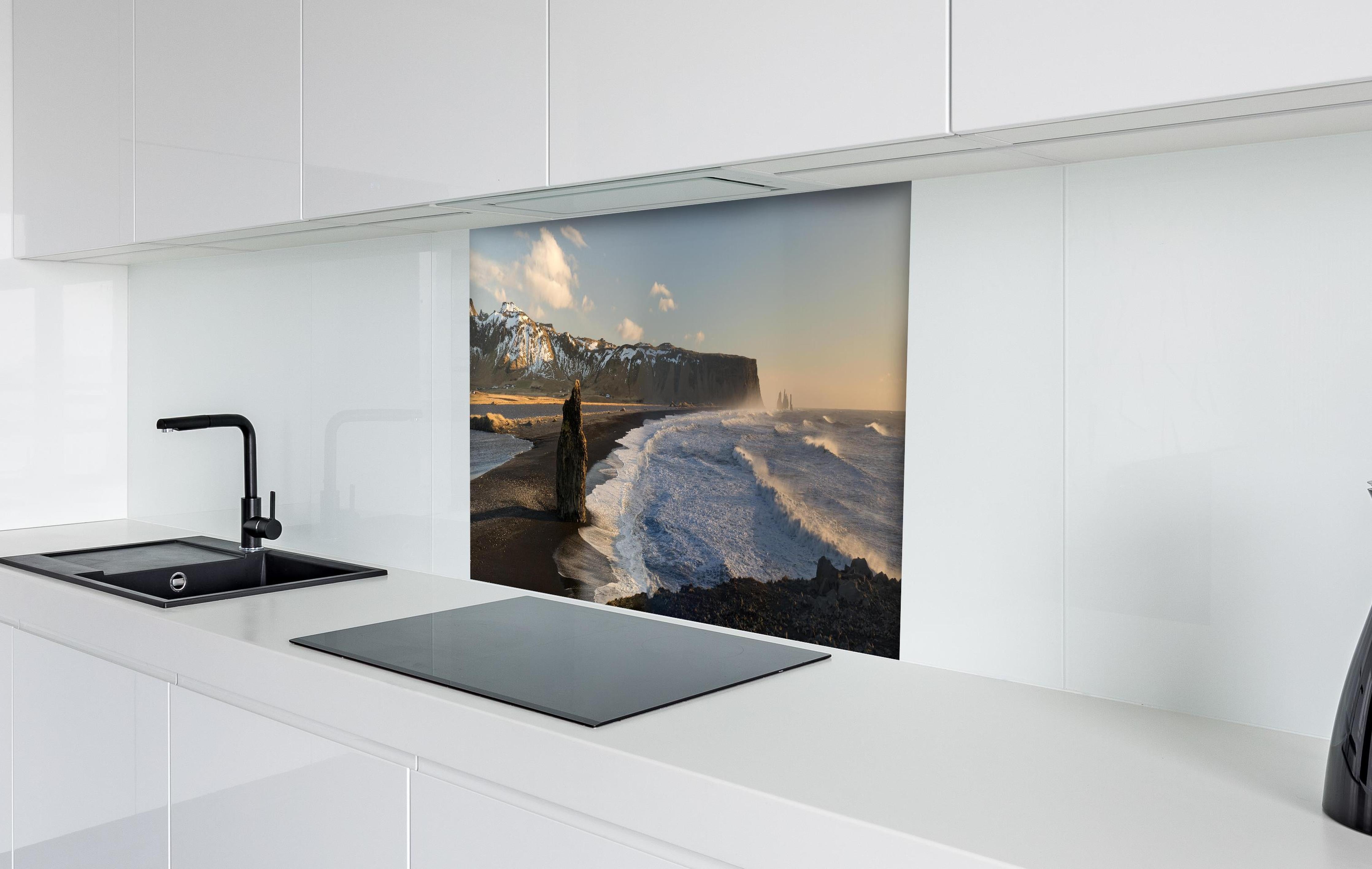 Spritzschutz - Schwarzer Strand von Dyrholaey hinter einem Cerankochfeld zwischen Holz-Kochutensilien
