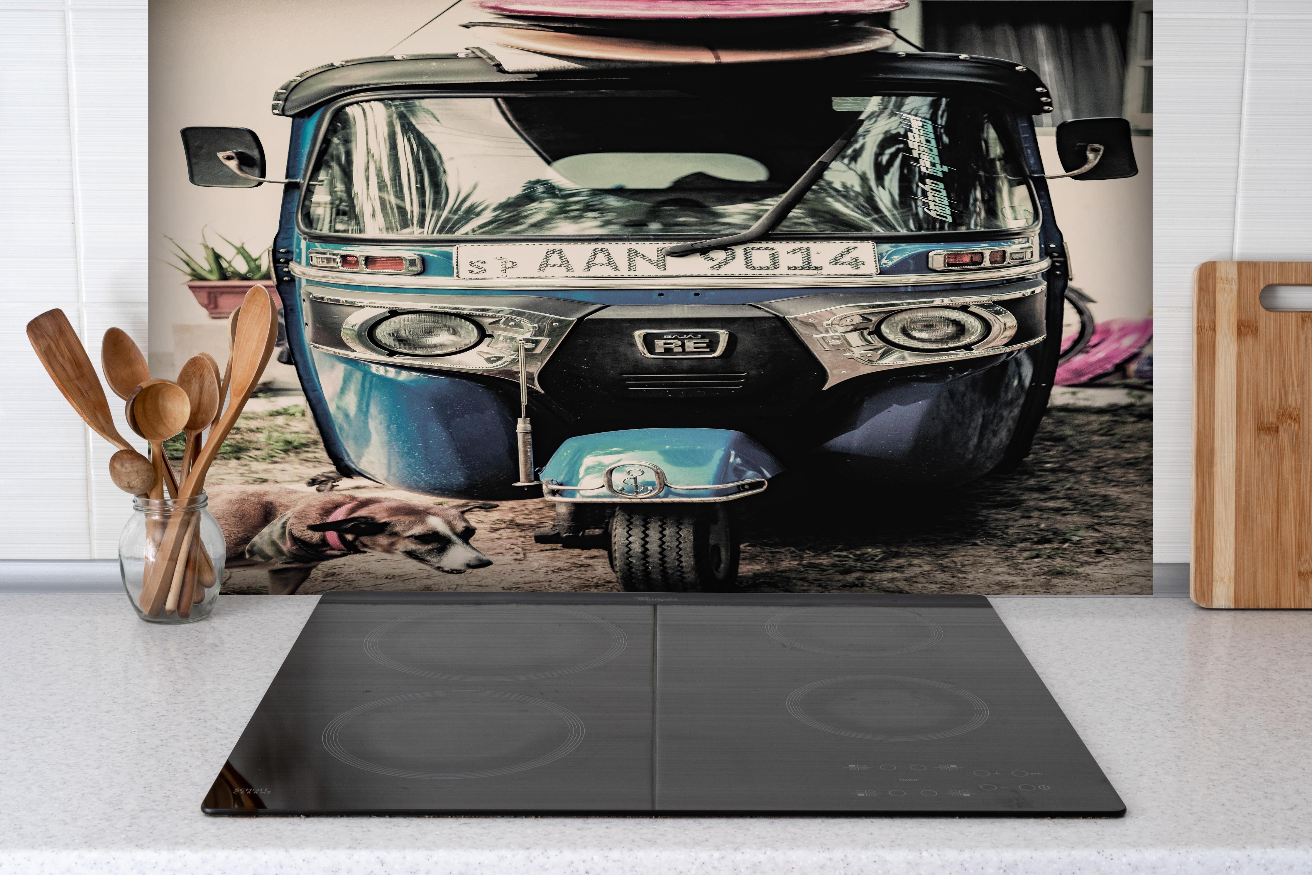 Spritzschutz - Self Drive hinter einem Cerankochfeld zwischen Holz-Kochutensilien
