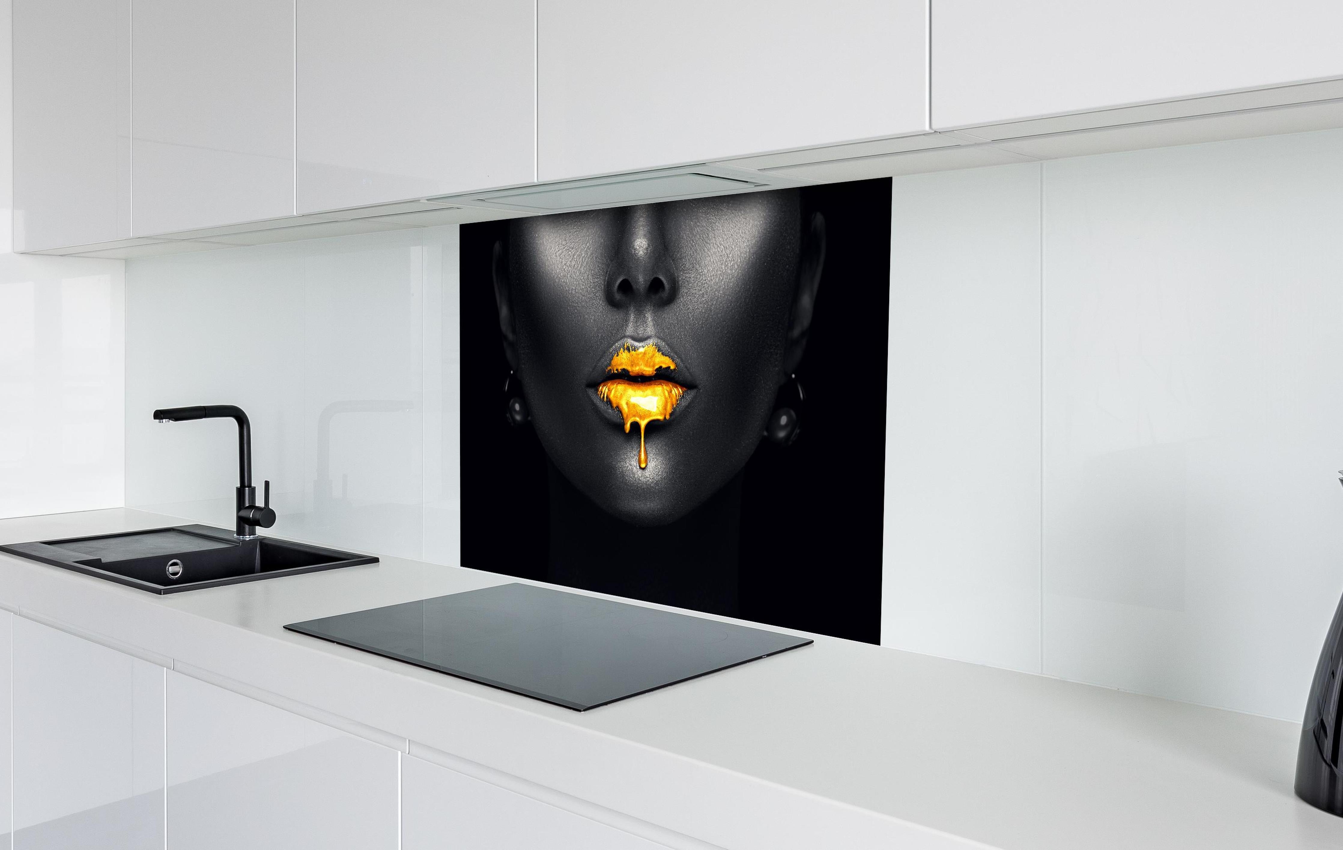 Spritzschutz - Sinnliche Lippen mit Goldtropfen hinter einem Cerankochfeld zwischen Holz-Kochutensilien
