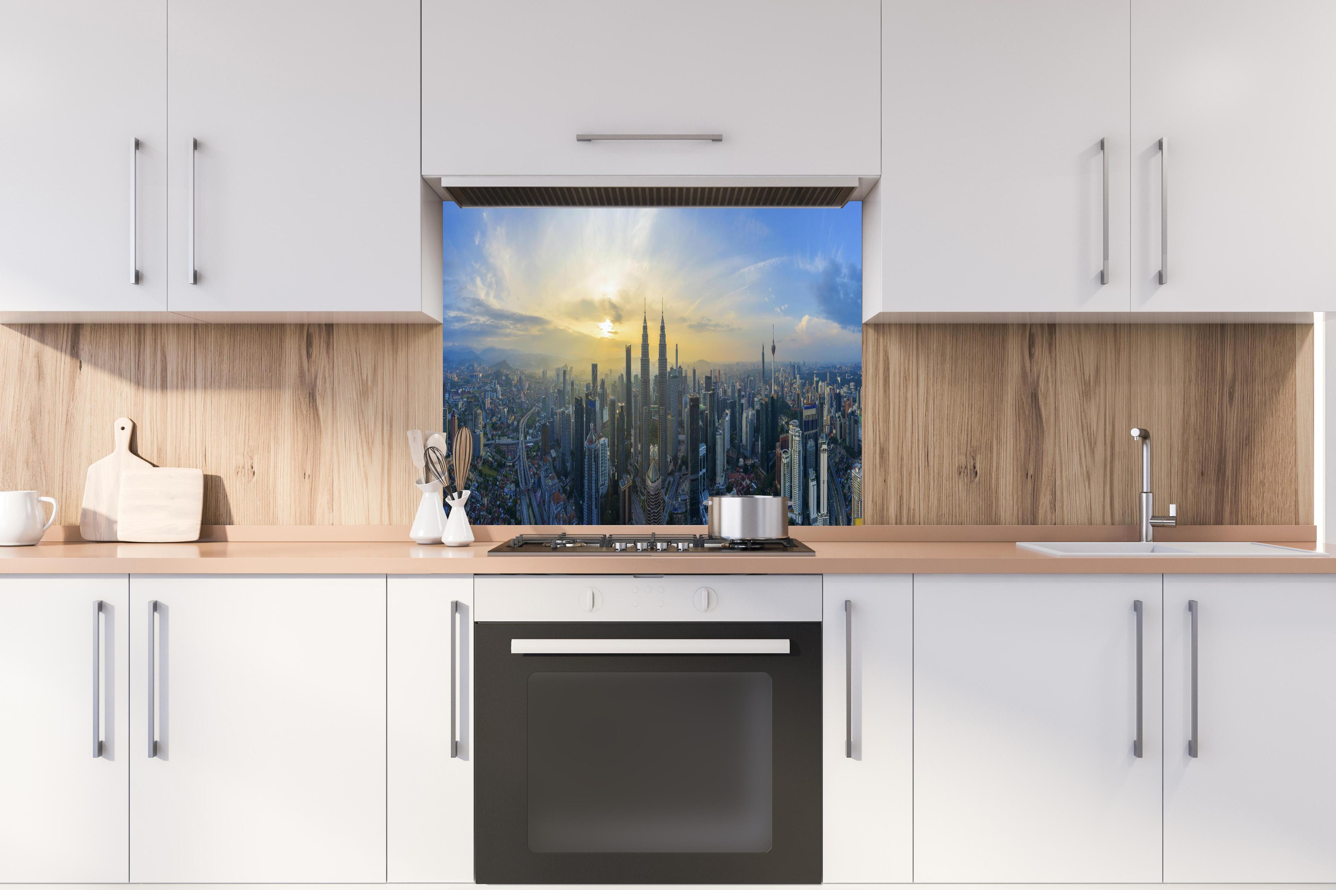 Spritzschutz - Skyline Kuala Lumpur City hinter einem Cerankochfeld zwischen Holz-Kochutensilien
