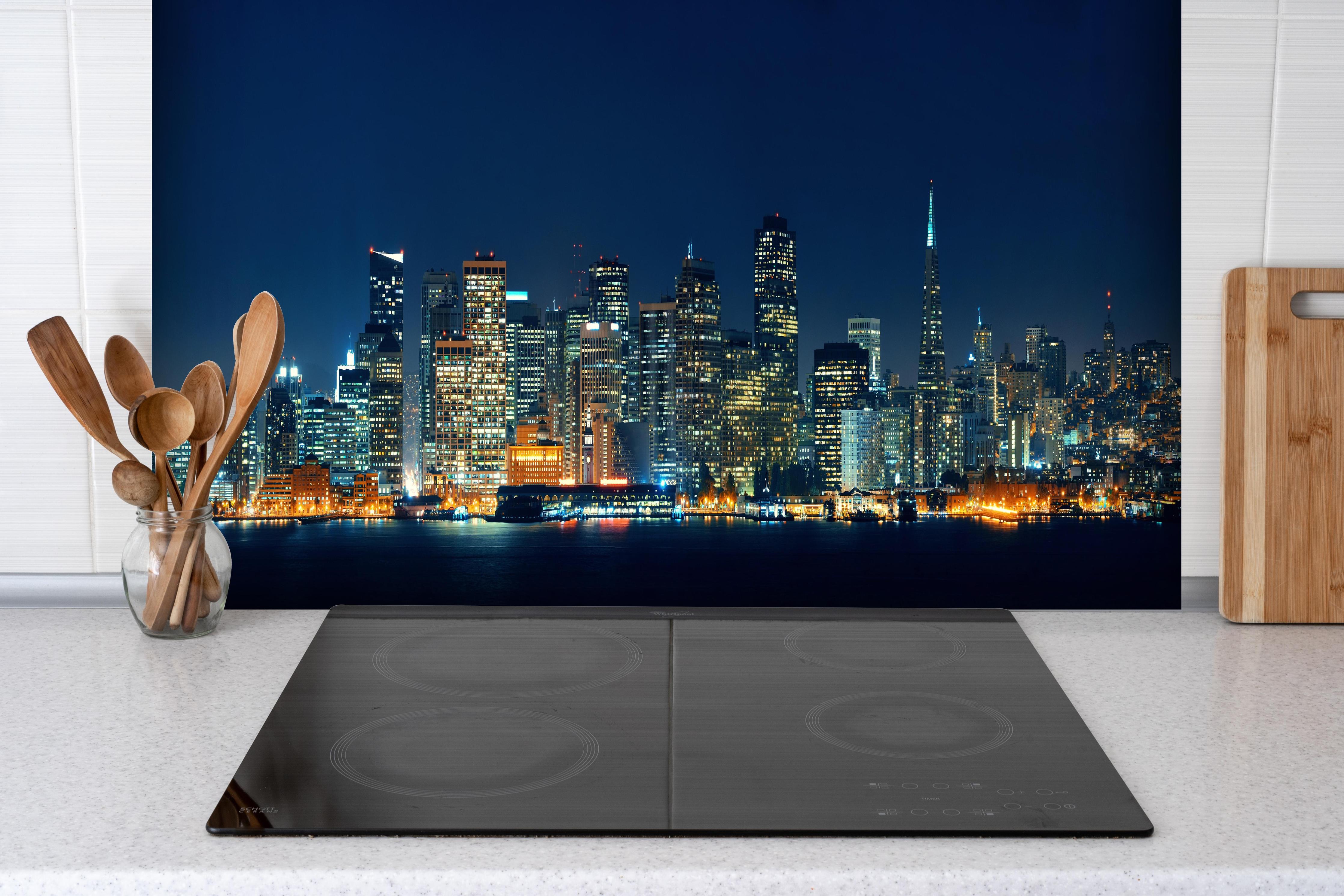 Spritzschutz - Skyline von San Francisco hinter einem Cerankochfeld zwischen Holz-Kochutensilien
