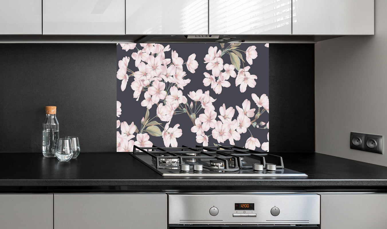 Spritzschutz - Somei Yoshino Sakura Blütenmuster hinter einem Cerankochfeld zwischen Holz-Kochutensilien
