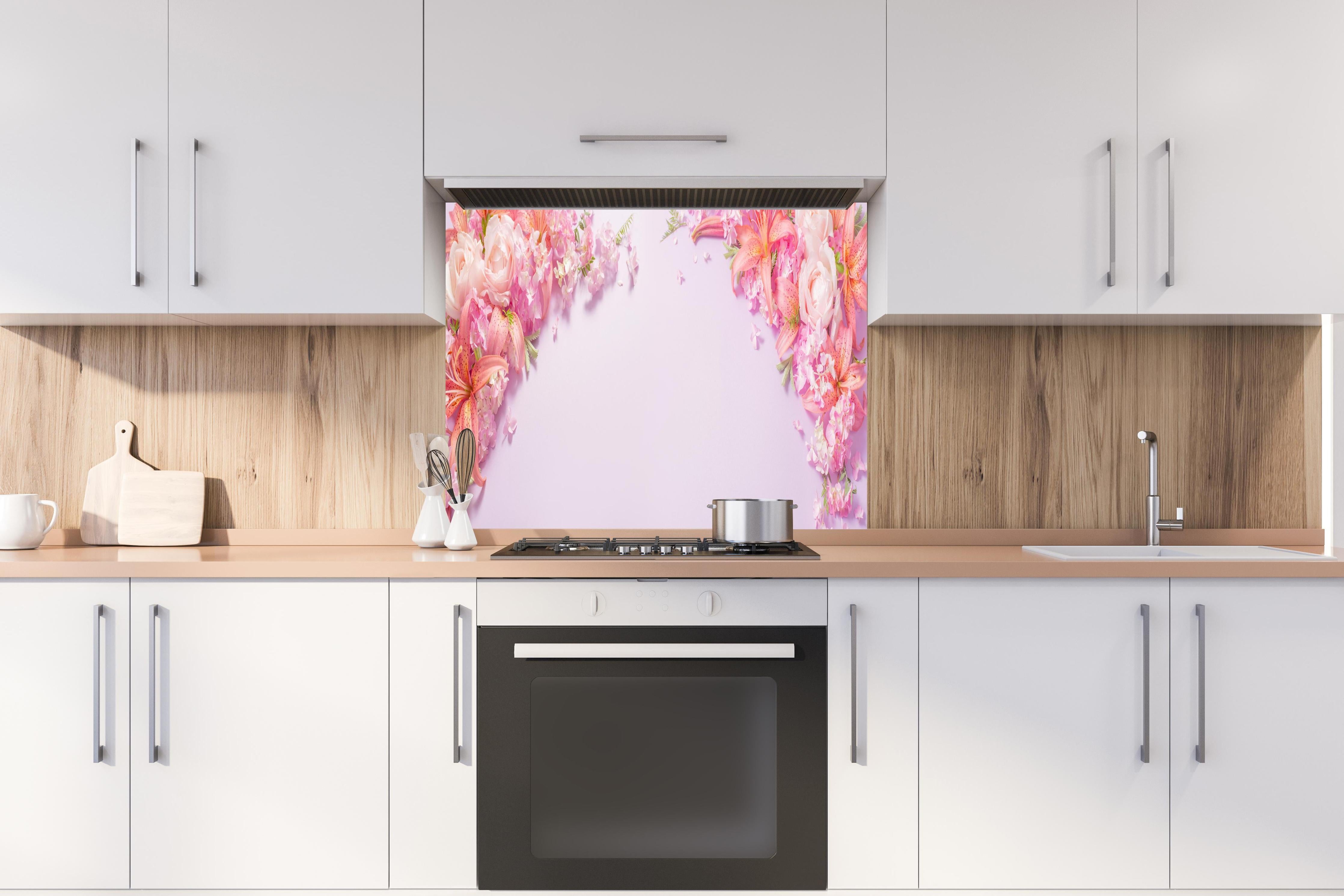 Spritzschutz - Sommerliche Blumenarrangements auf Papier hinter einem Cerankochfeld zwischen Holz-Kochutensilien
