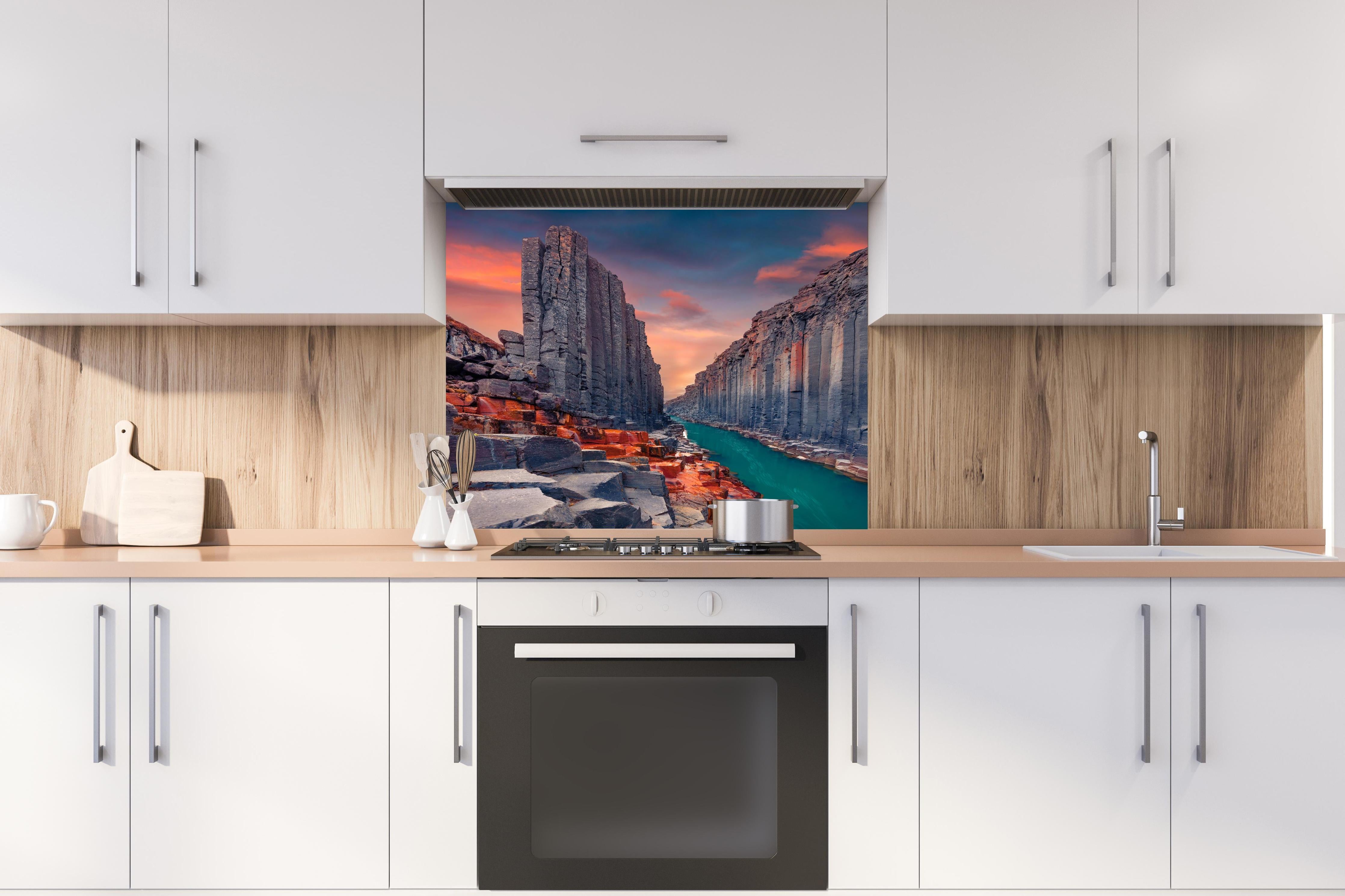 Spritzschutz - Sommerlicher Sonnenaufgang - Studlagil-Schlucht hinter einem Cerankochfeld zwischen Holz-Kochutensilien
