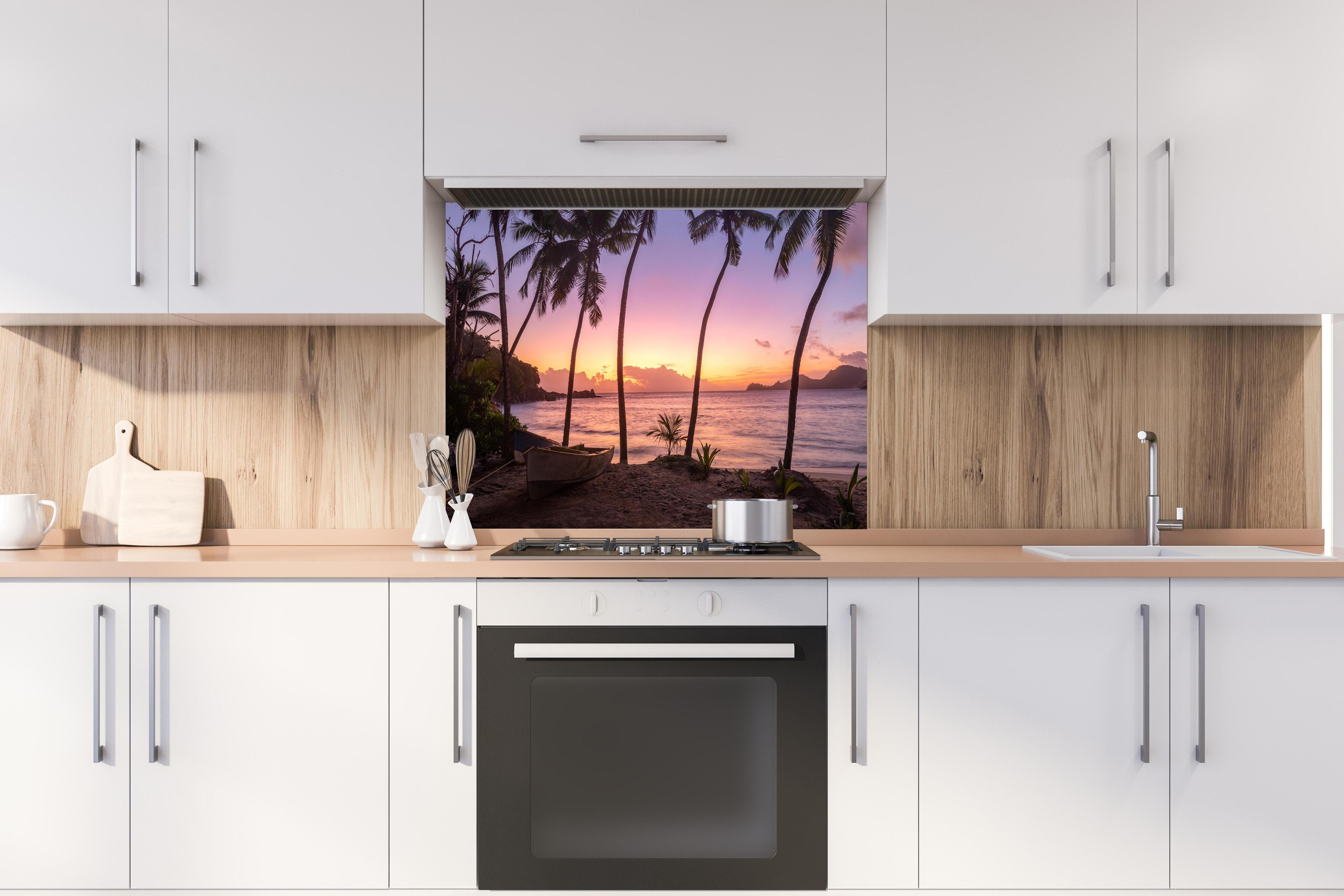 Spritzschutz - Sonnenuntergang am Strand Anse Takamaka hinter einem Cerankochfeld zwischen Holz-Kochutensilien
