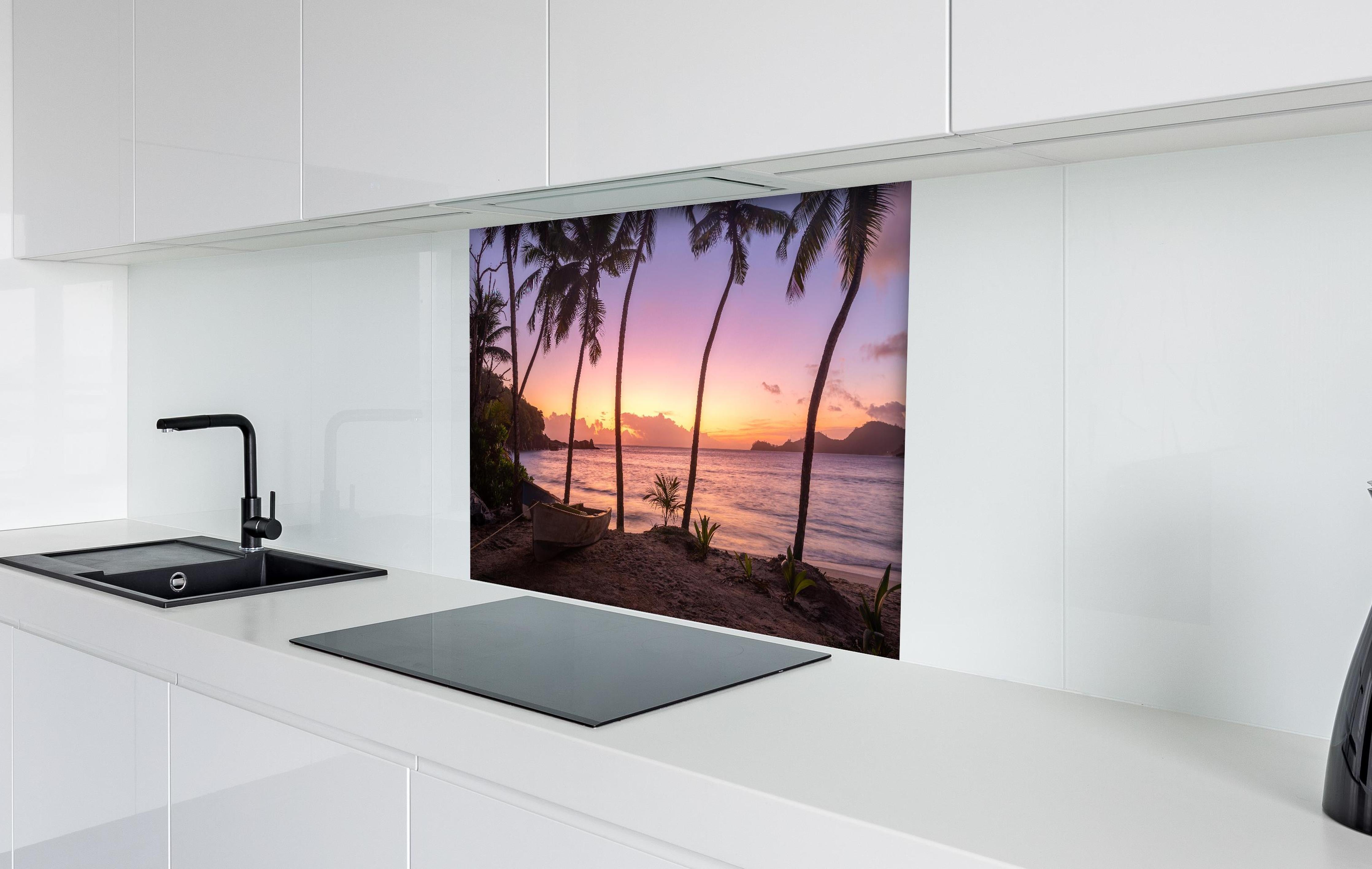 Spritzschutz - Sonnenuntergang am Strand Anse Takamaka hinter einem Cerankochfeld zwischen Holz-Kochutensilien
