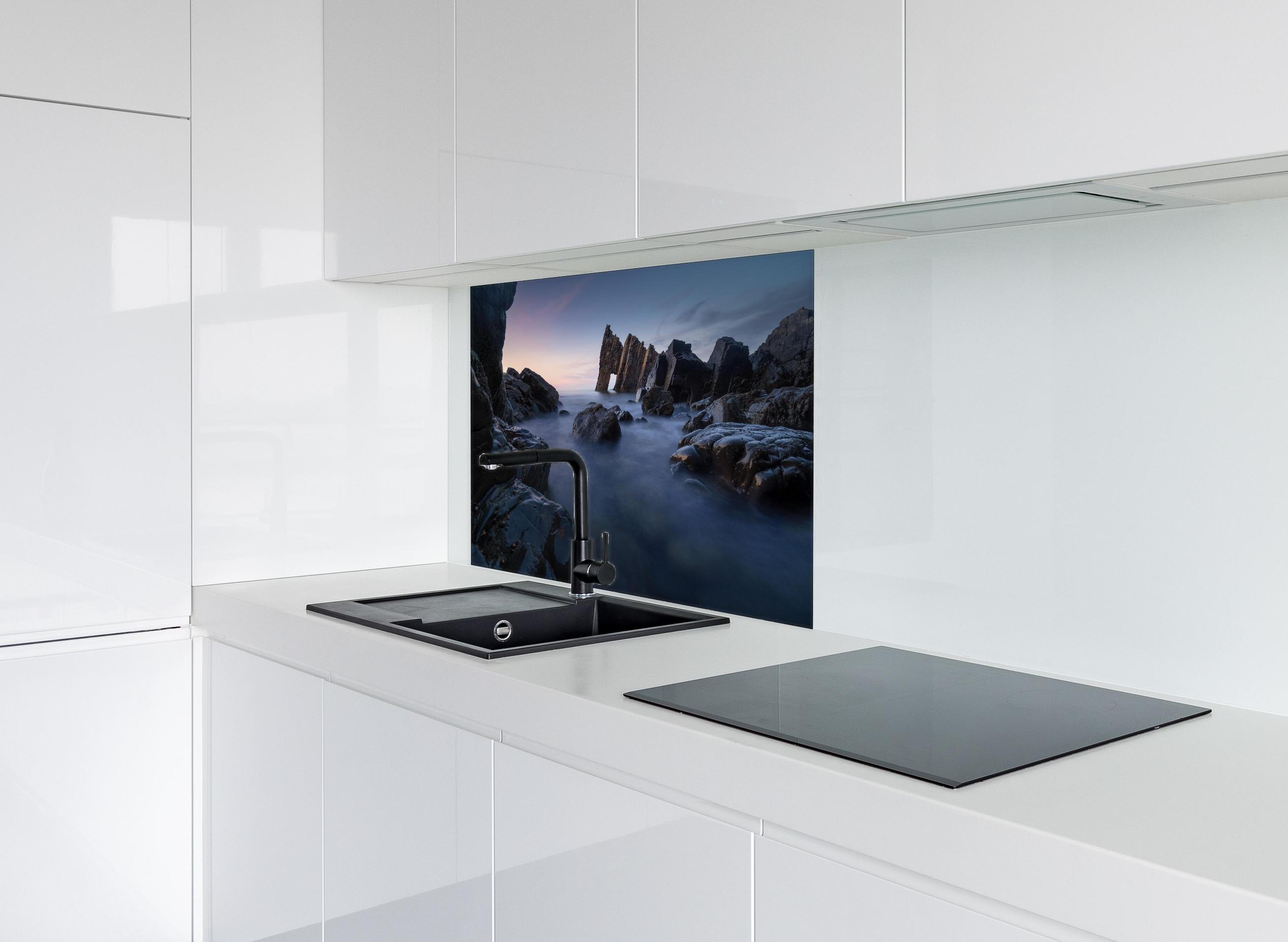 Spritzschutz - Sonnenuntergang am felsigen Meeresufer hinter einem Cerankochfeld zwischen Holz-Kochutensilien
