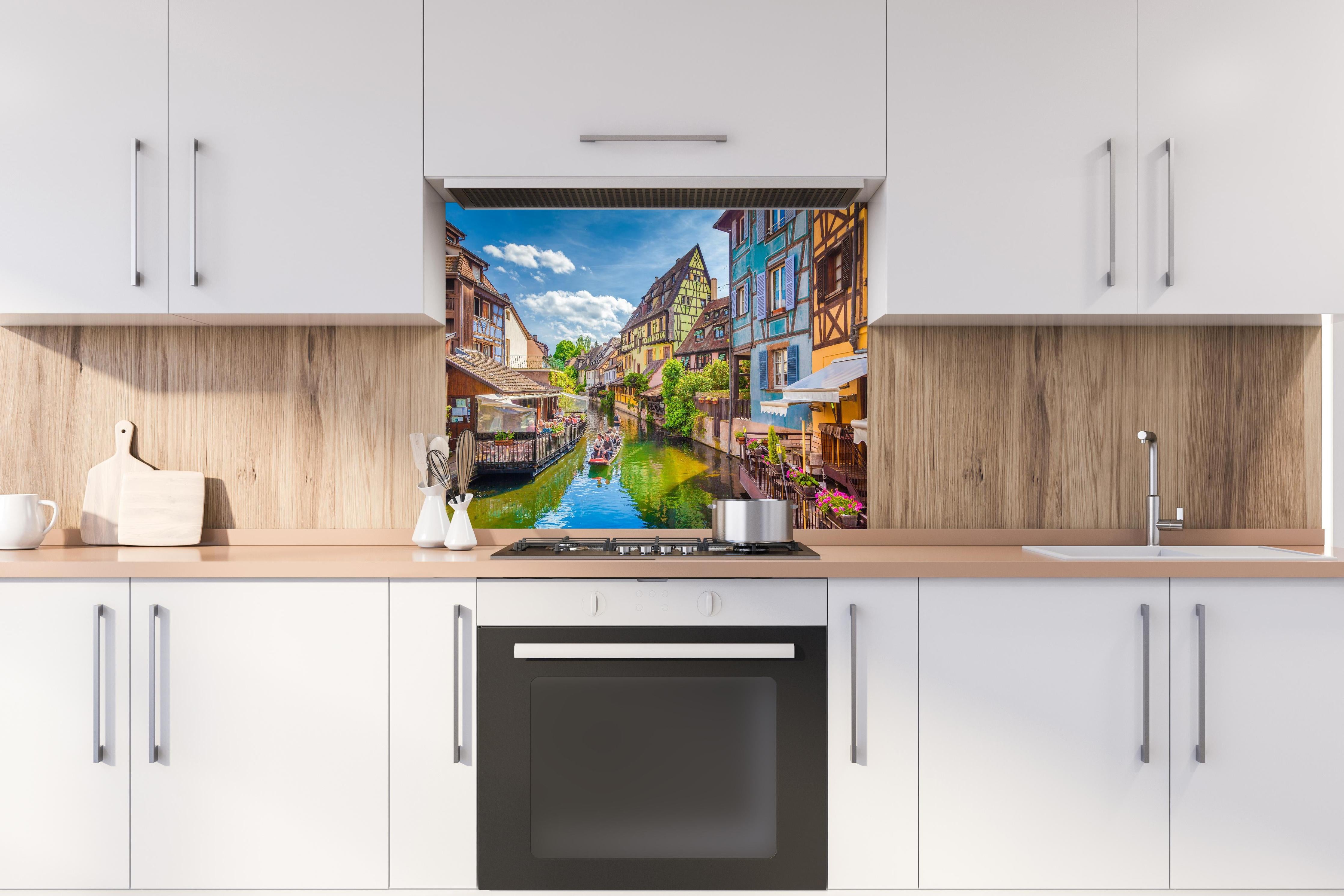Spritzschutz - Sonnige Bootstour Colmar hinter einem Cerankochfeld zwischen Holz-Kochutensilien
