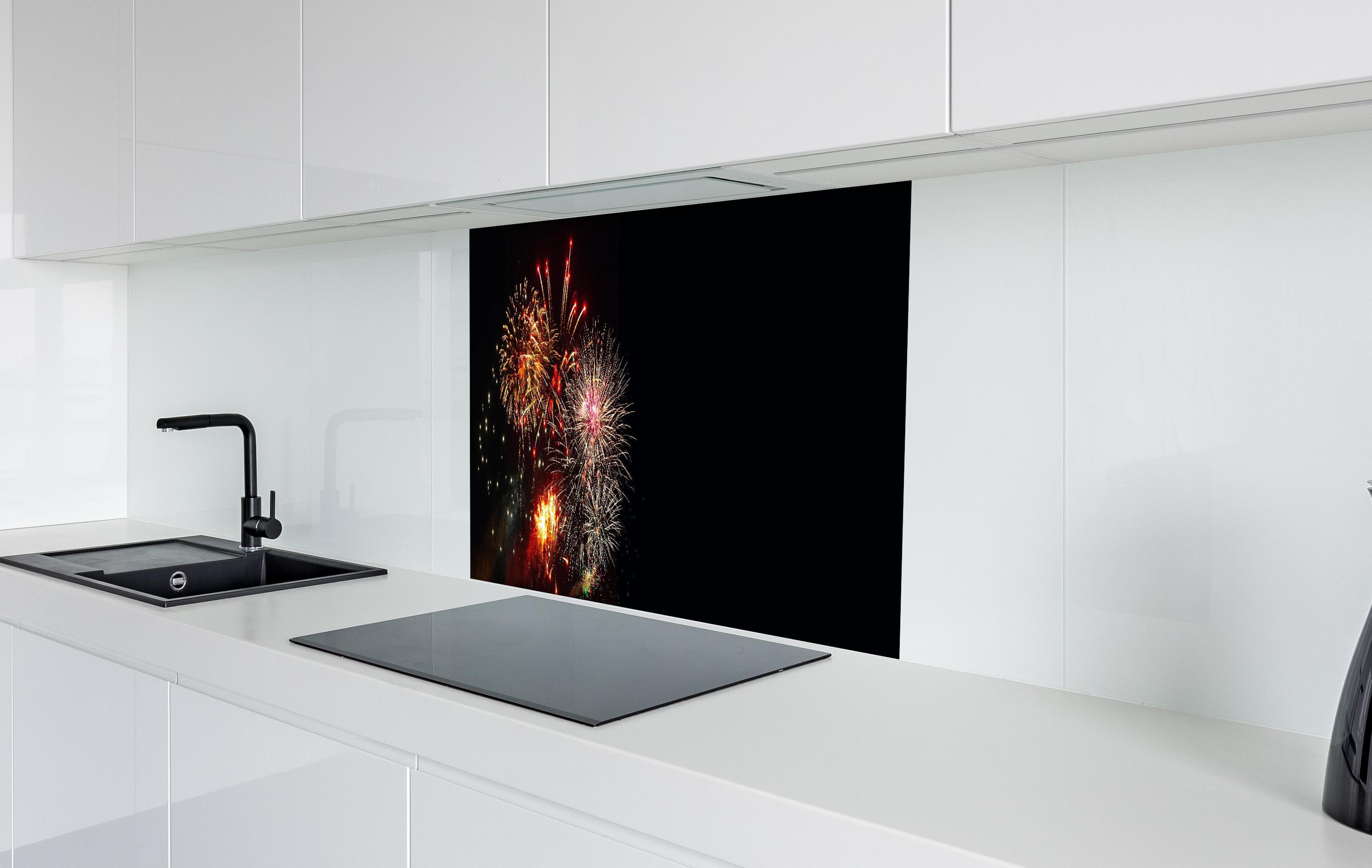 Spritzschutz - Spektakuläres Neujahrsfeuerwerk in Nacht hinter einem Cerankochfeld zwischen Holz-Kochutensilien
