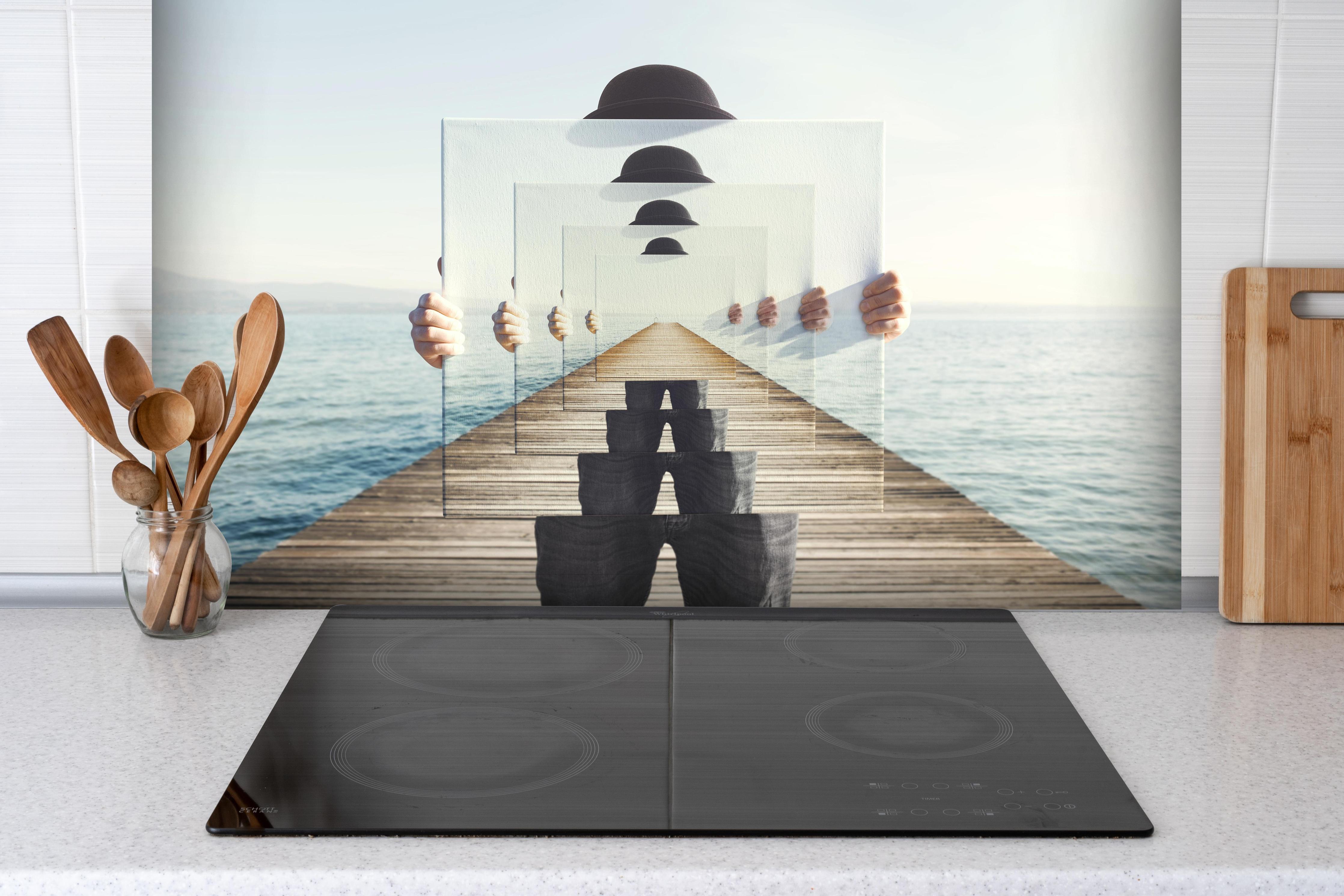 Spritzschutz - Spiegel-Illusion auf einem Meeres-Steg hinter einem Cerankochfeld zwischen Holz-Kochutensilien
