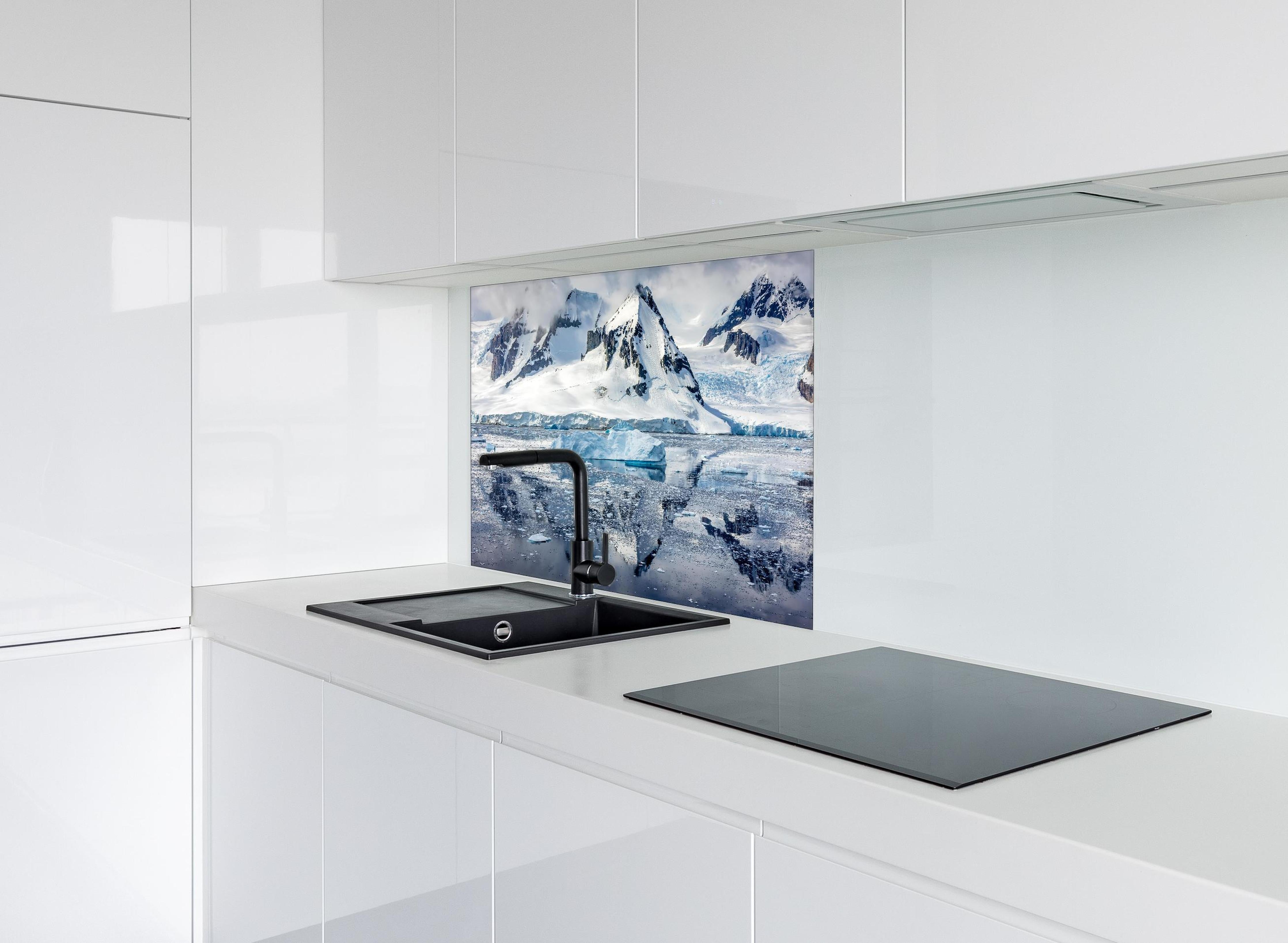 Spritzschutz - Spiegelung eines antarktischen Eisbergs hinter einem Cerankochfeld zwischen Holz-Kochutensilien
