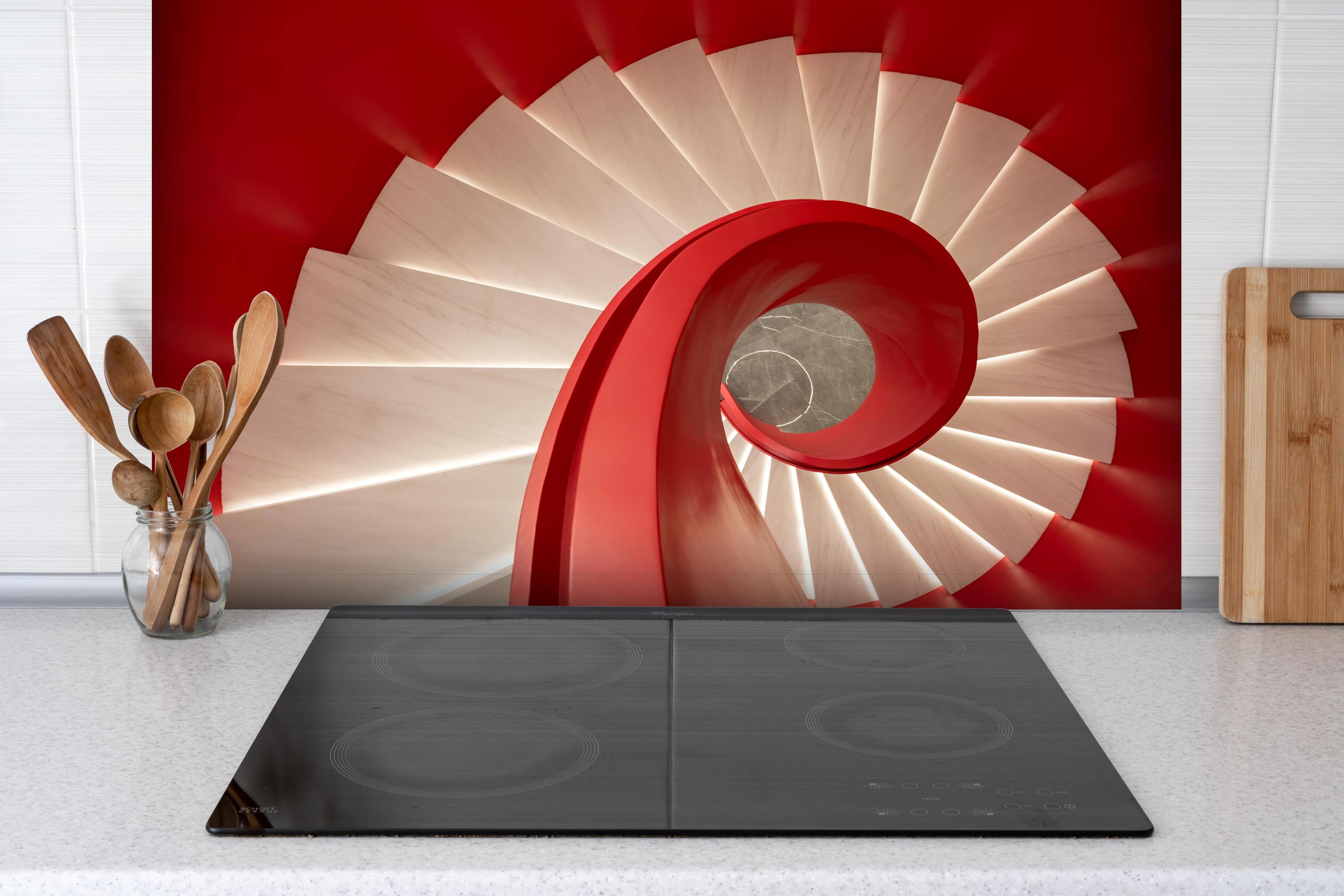 Spritzschutz - Spirale Treppe - Rötlich hinter einem Cerankochfeld zwischen Holz-Kochutensilien
