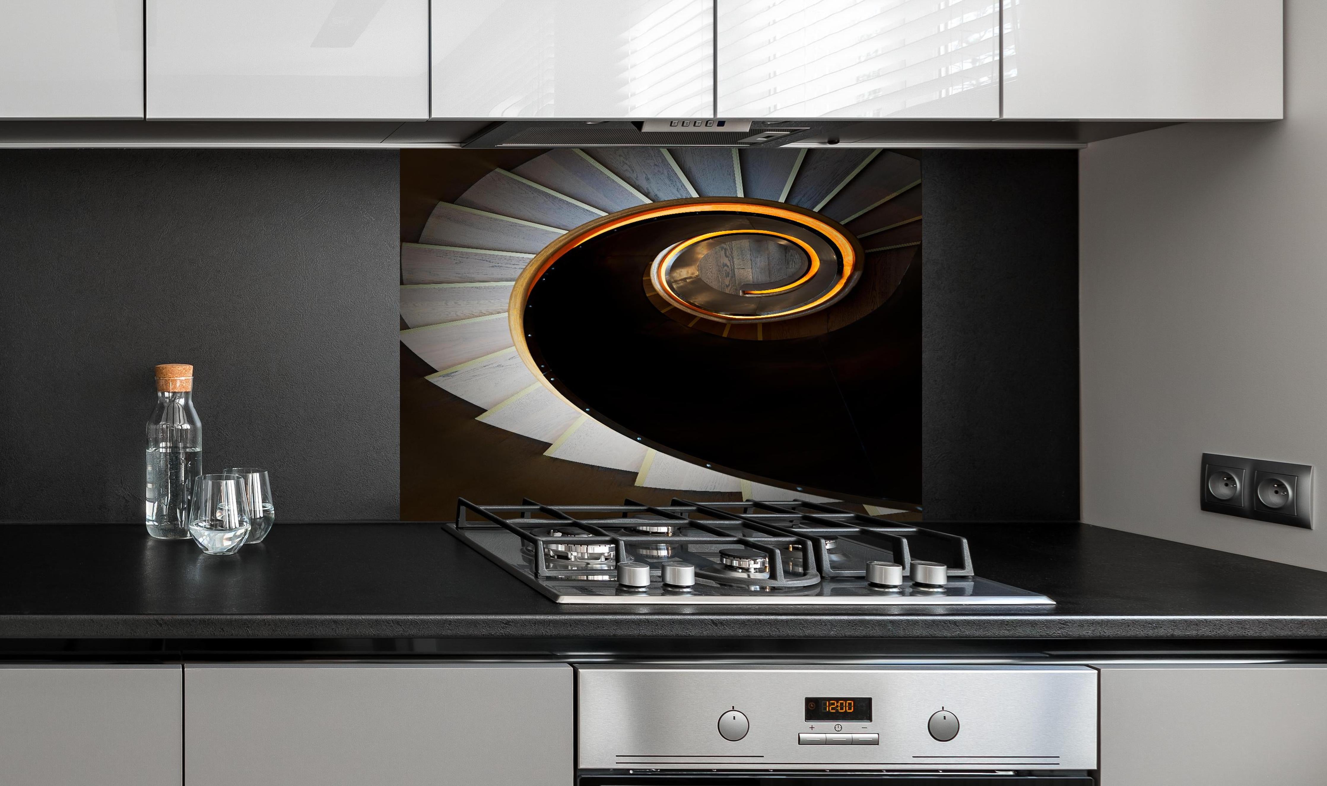 Spritzschutz - Spiraltreppe mit orangen Akzenten und dunklen Stufen hinter einem Cerankochfeld zwischen Holz-Kochutensilien
