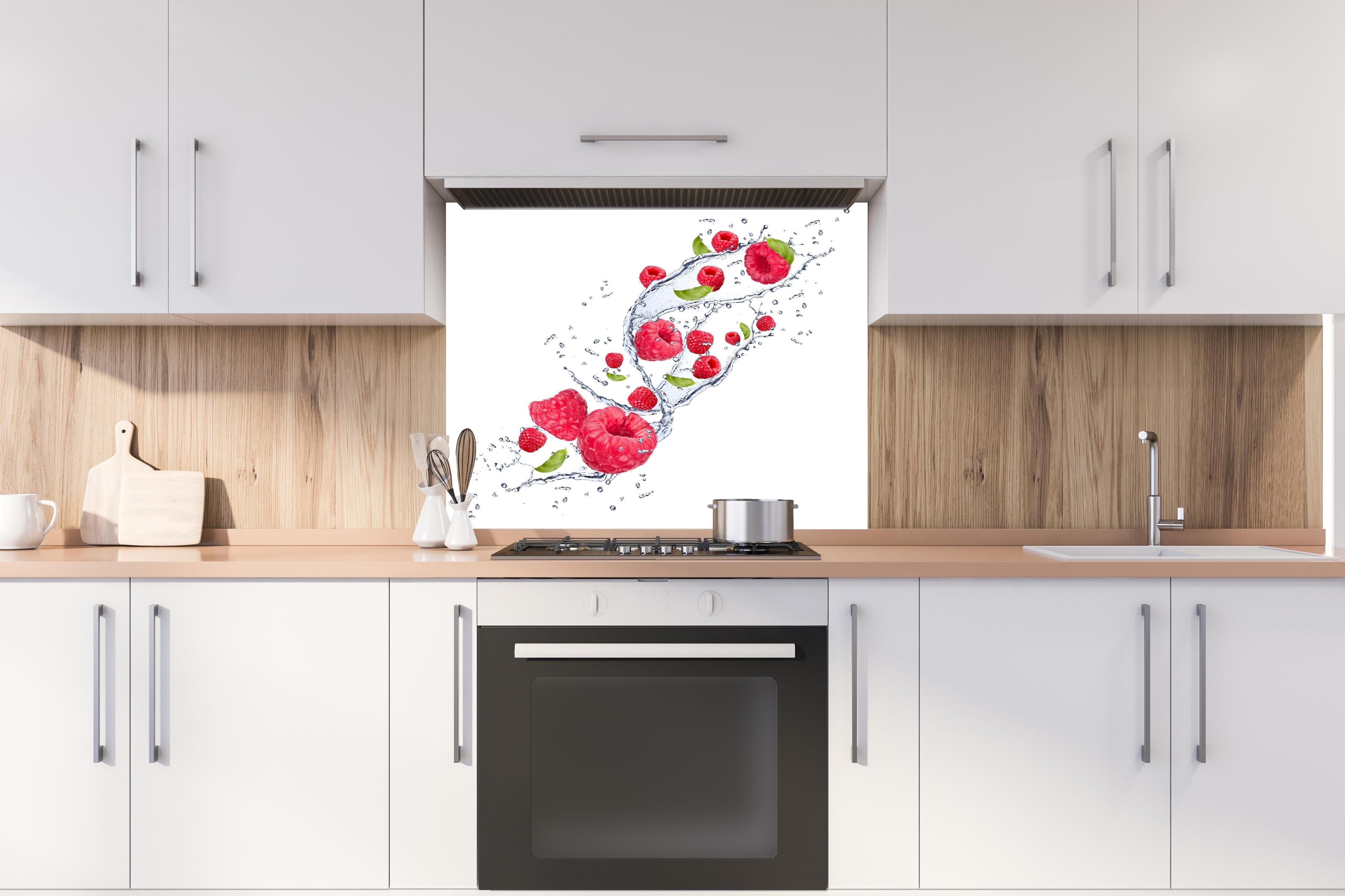 Spritzschutz - Spritzige Erdbeeren hinter einem Cerankochfeld zwischen Holz-Kochutensilien
