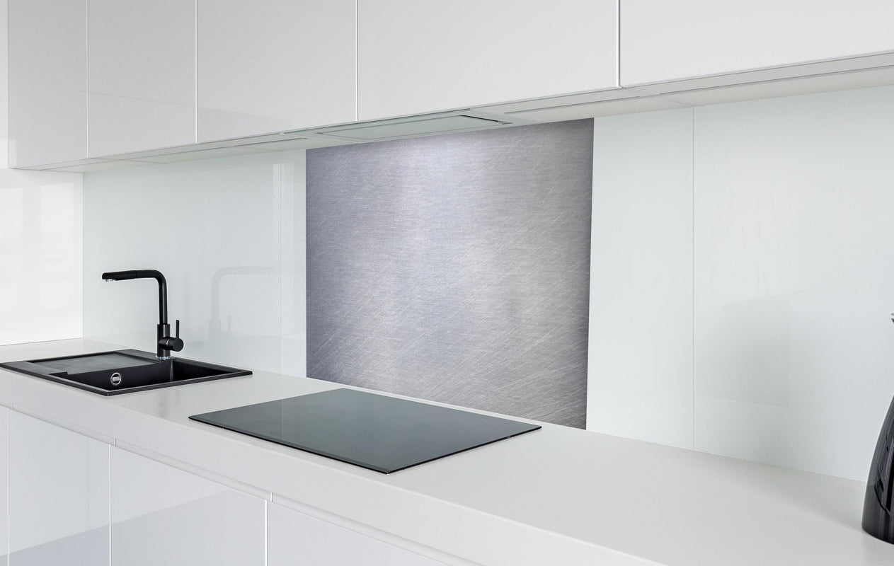 Spritzschutz -  Gebürsteter Stahl  in weißer Hochglanz-Küche hinter einem Cerankochfeld